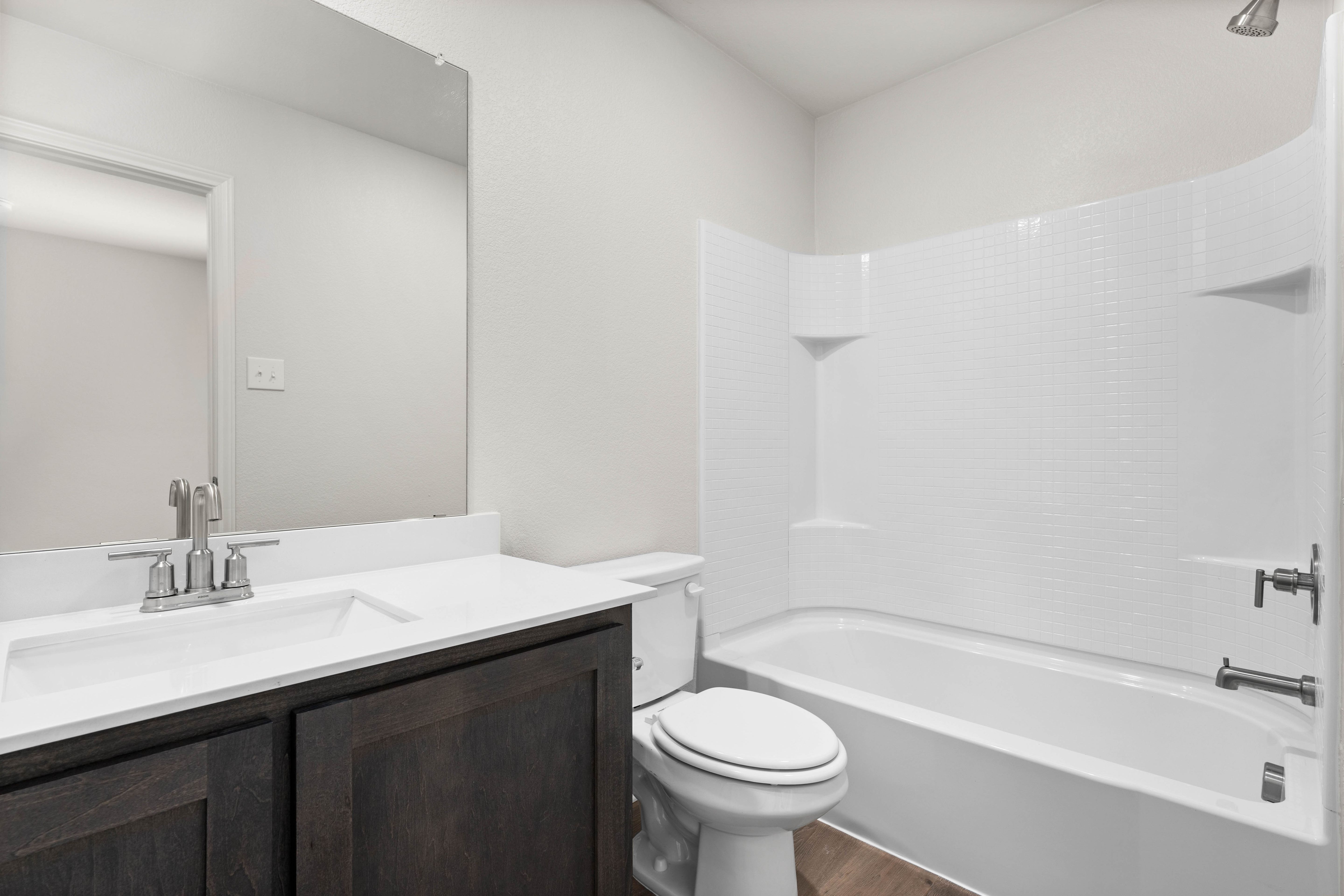 The secondary bathroom has a spacious vanity and shower-tub combo.