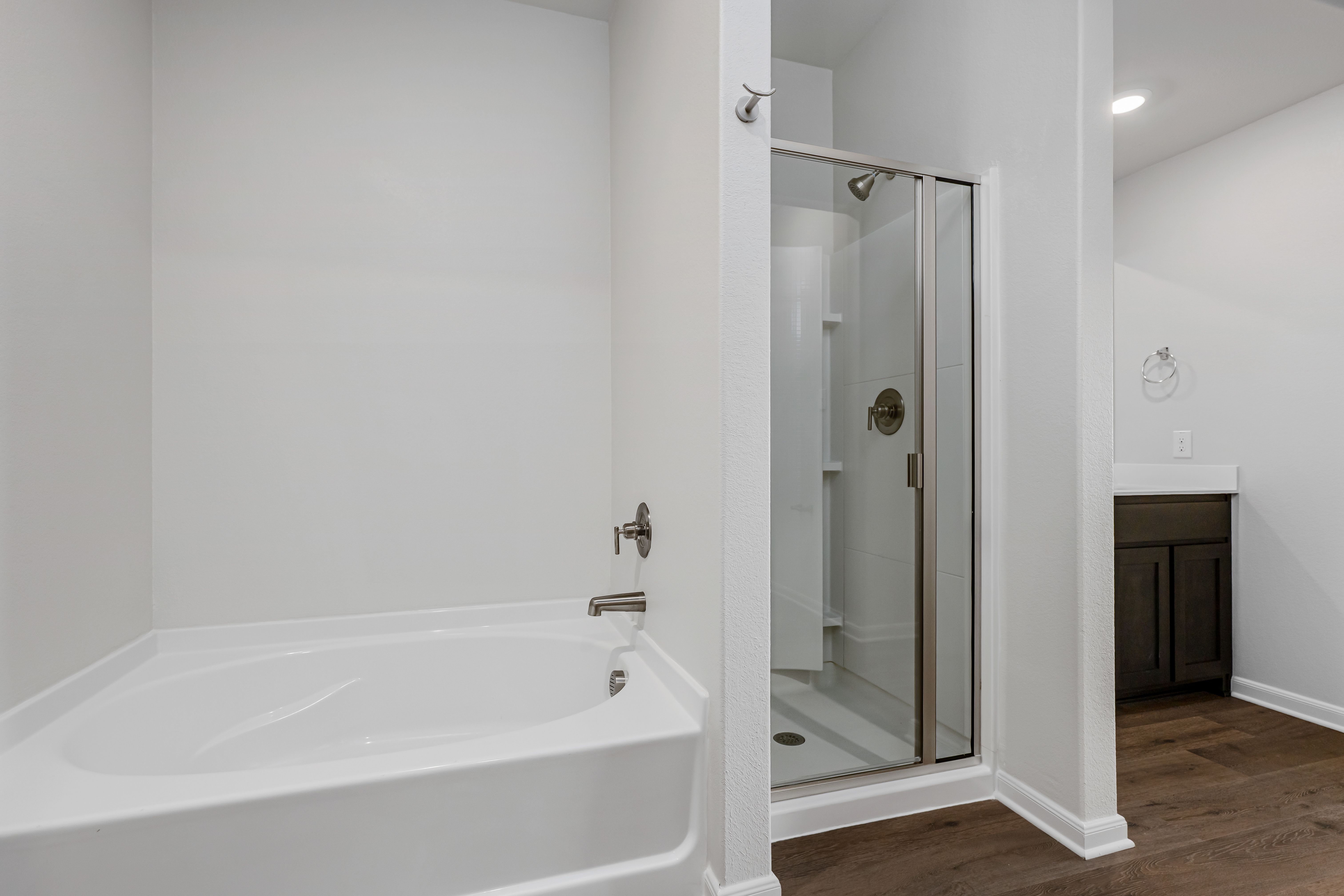 The master bathroom has a garden tub and a glass, walk-in shower.