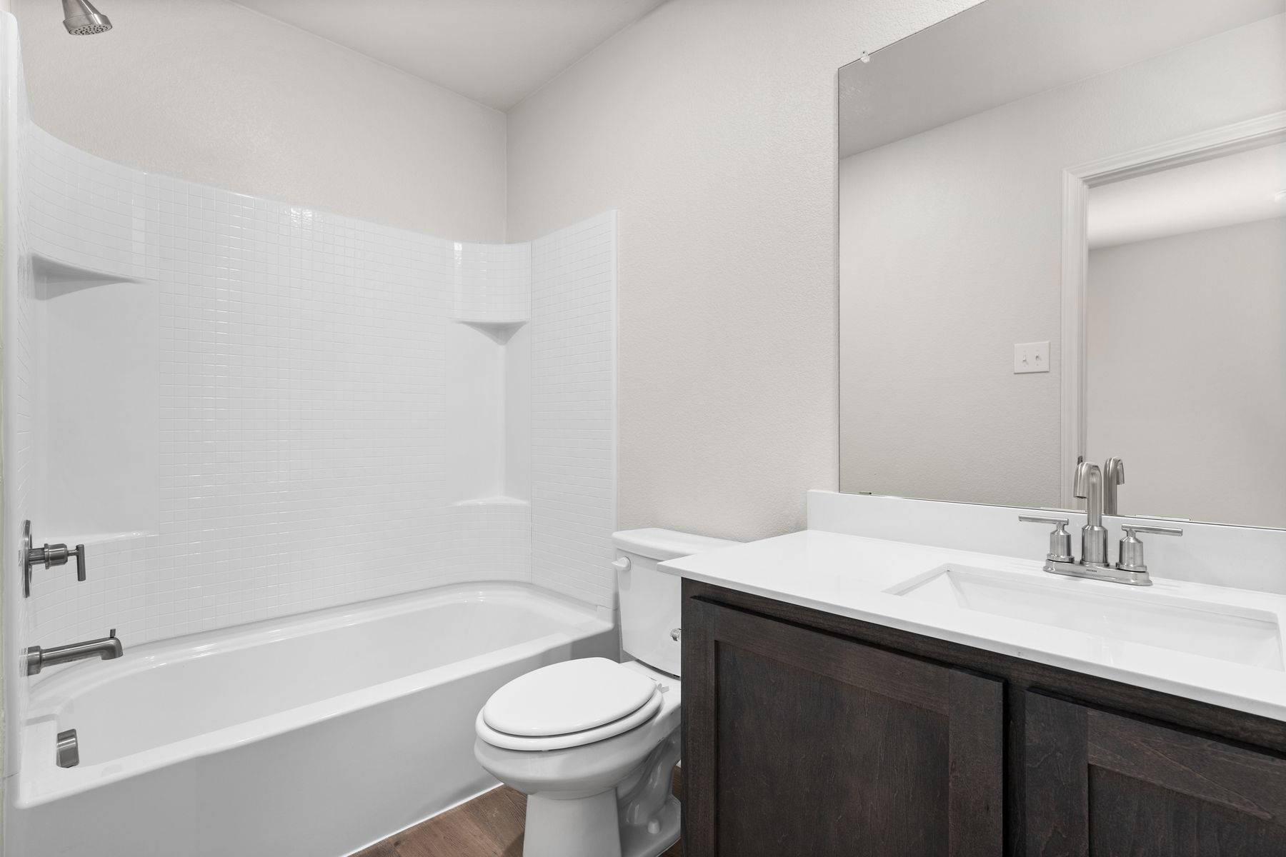 The secondary bathroom has a spacious vanity and shower-tub combo.