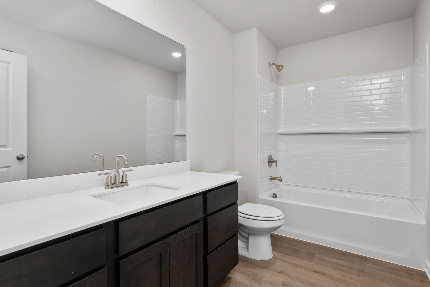 The secondary bathroom has a sprawling vanity and a shower-tub combo.