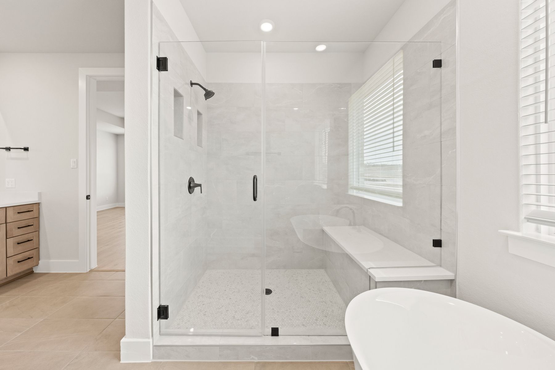 The glass walk-in shower has a wonderful built-in bench and shelves.