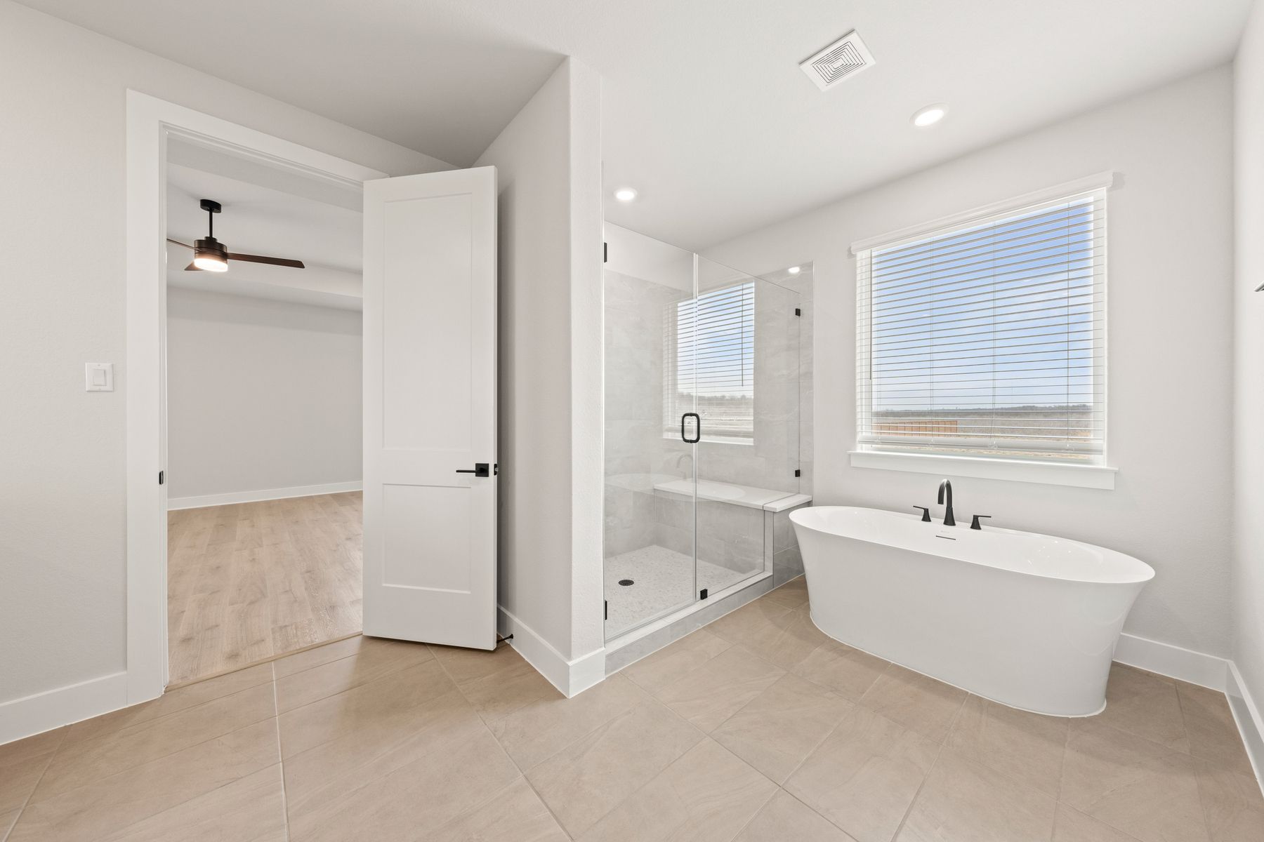 The master bathroom has a garden tub and glass, walk-in shower.