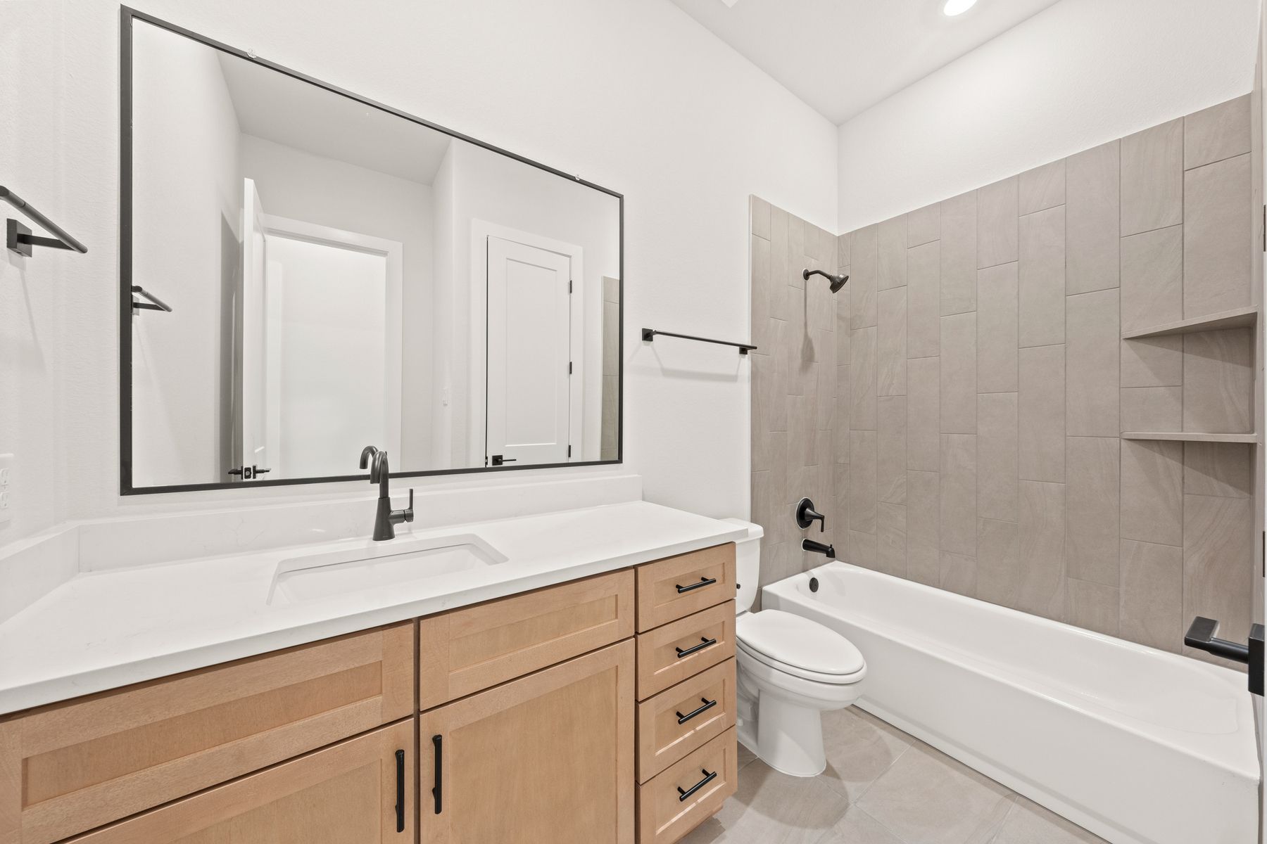 The secondary bathroom has a sprawling vanity space and a shower-tub combo.