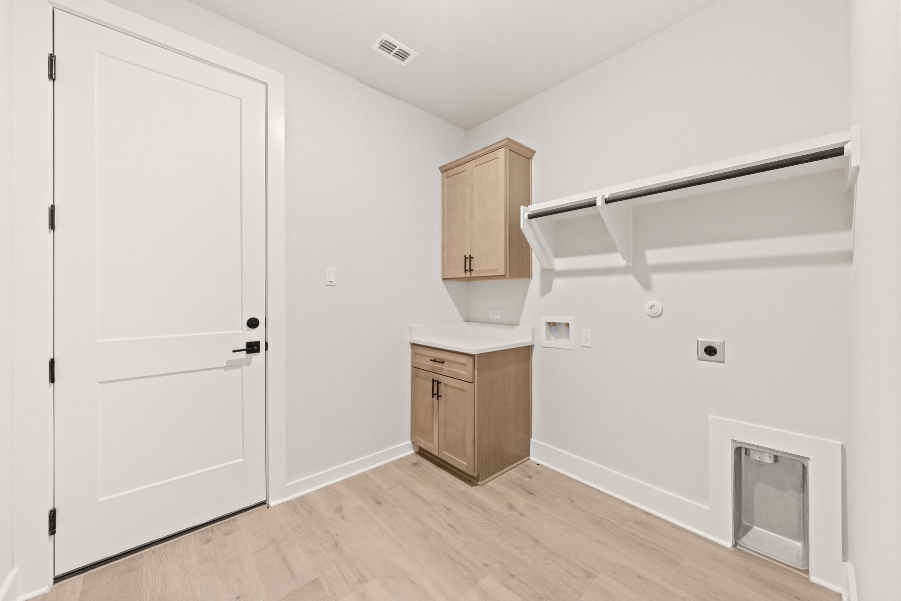 The laundry room has cabinets and a counter for additional convenience.