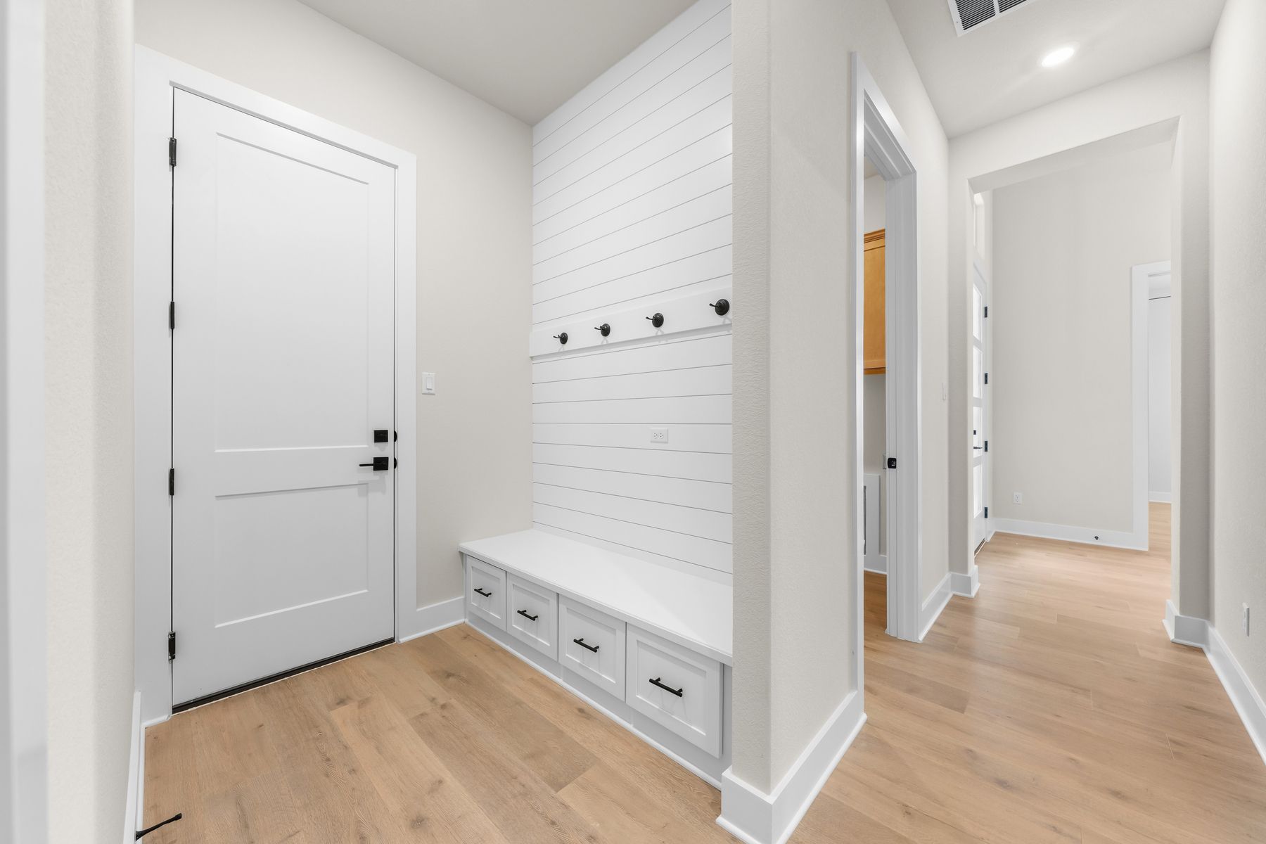 The mudroom has a great drop zone with hooks and a storage bench.
