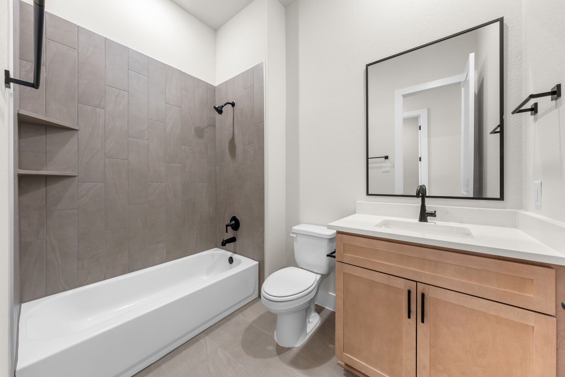 The secondary bathroom has a vanity and shower-tub combo.