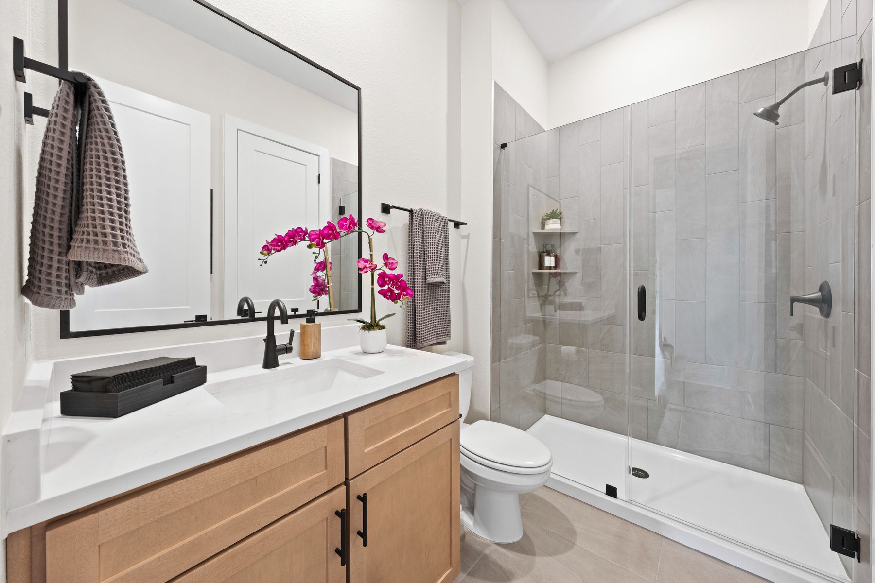 The secondary bathroom has a sprawling vanity and glass, walk-in shower.