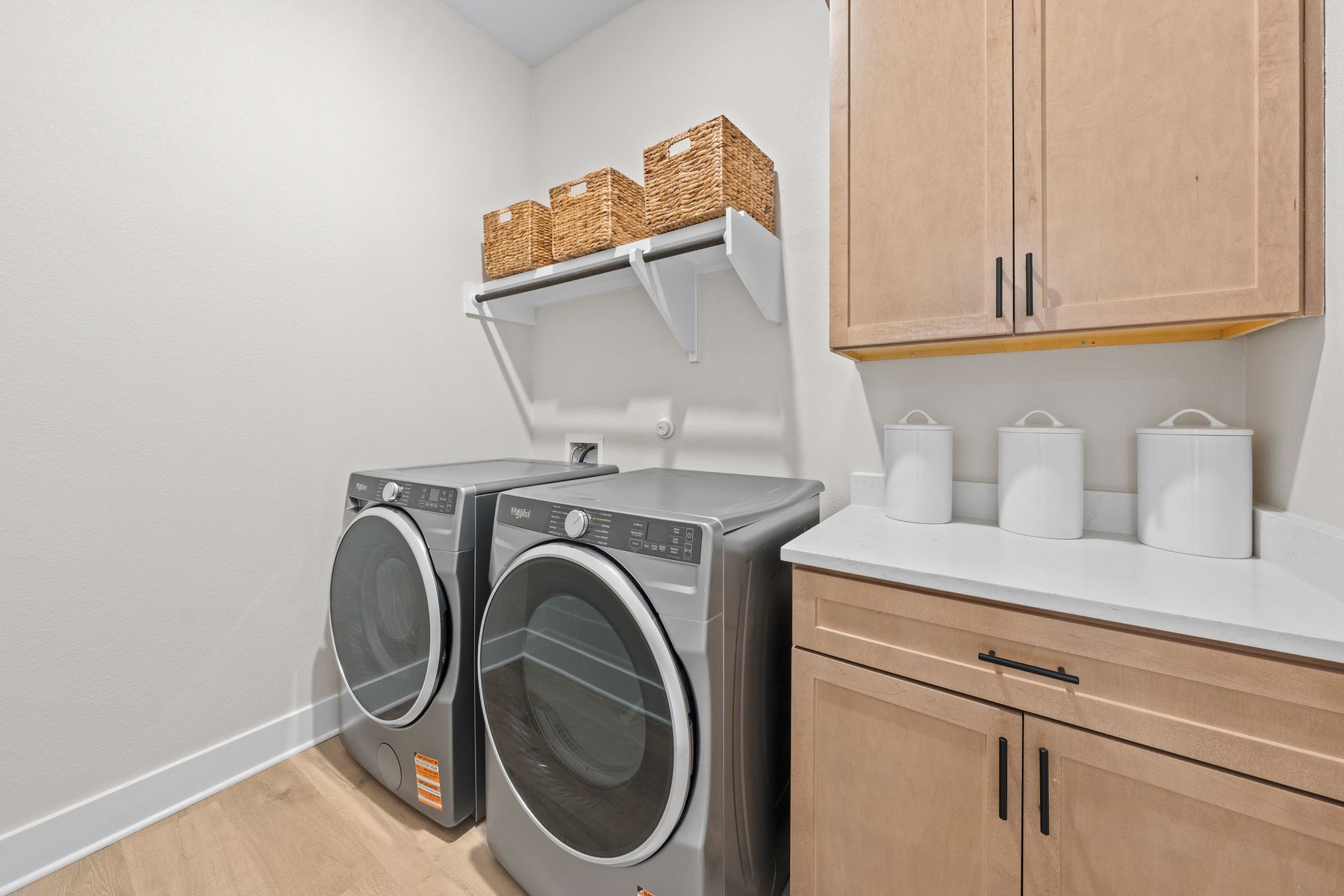 The laundry room has cabinets and counterspace.