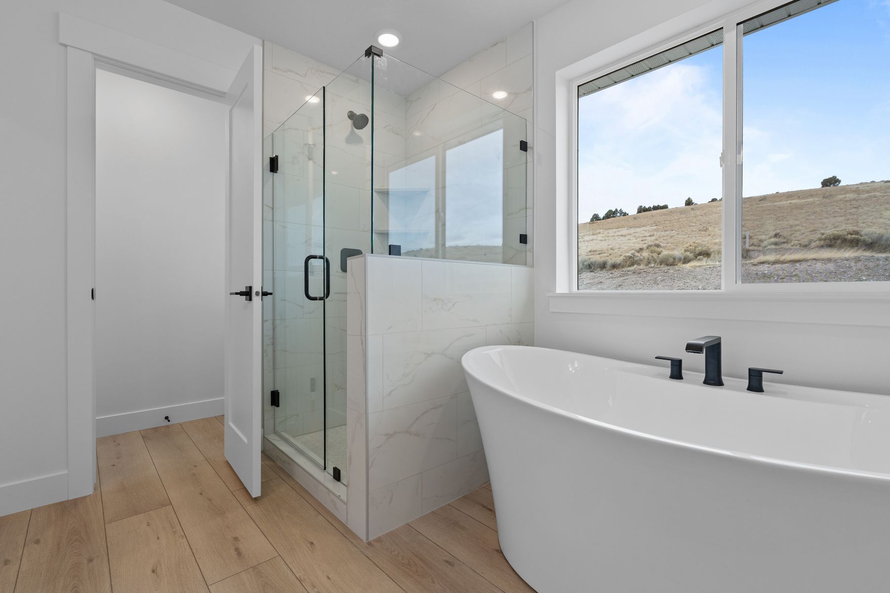 The master bathroom has a stand-alone tub and glass, walk-in shower.