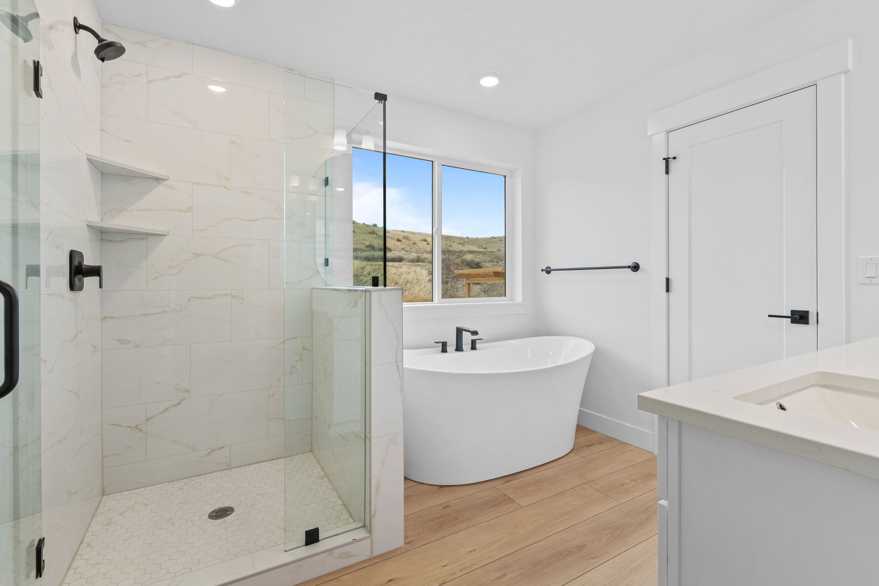 The glass, walk-in shower has beautiful tile walls and floor. 