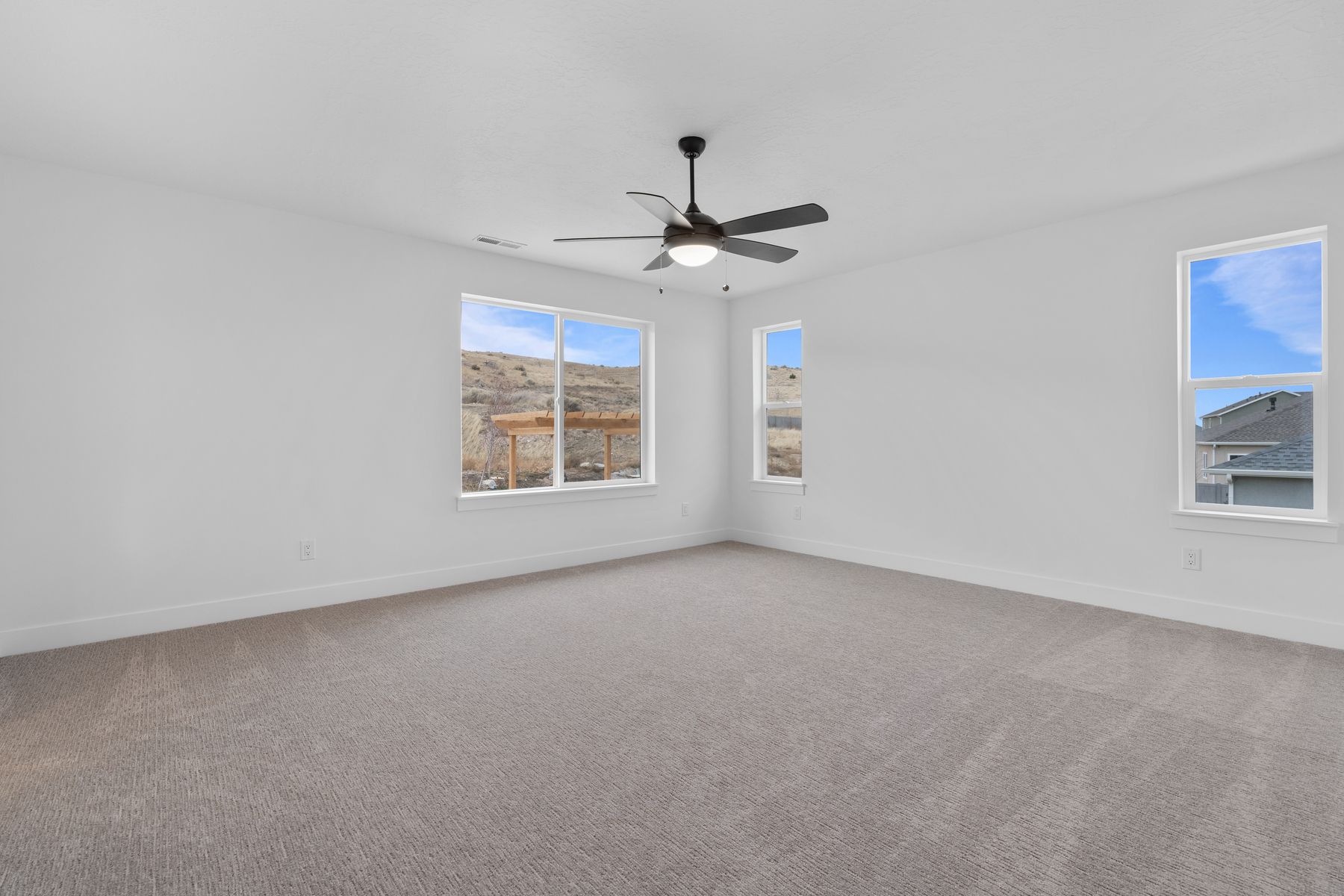The master bedroom is spacious and has multiple windows that let in great, natural light.