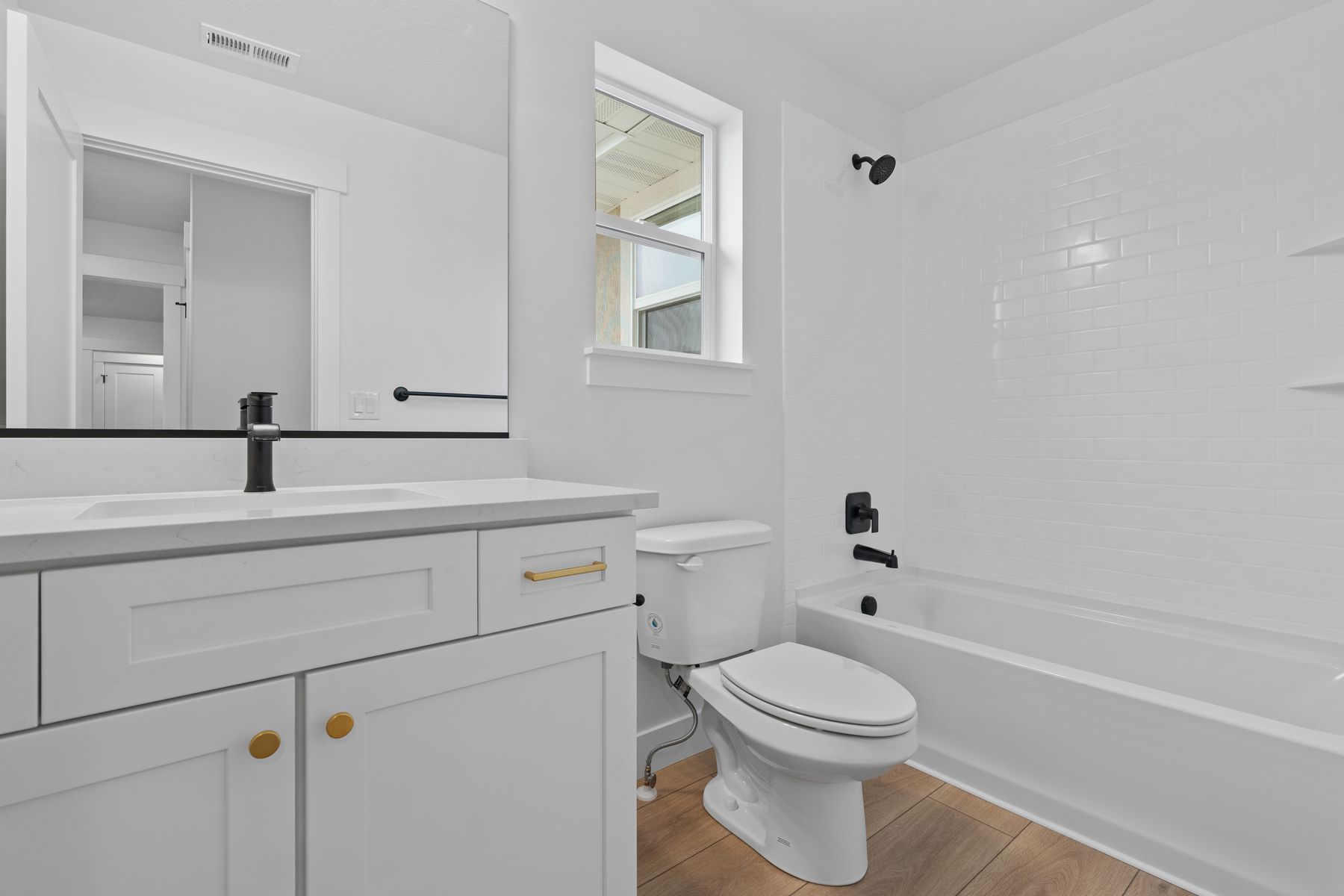 The secondary bathroom has a quartz vanity and shower-tub combo.