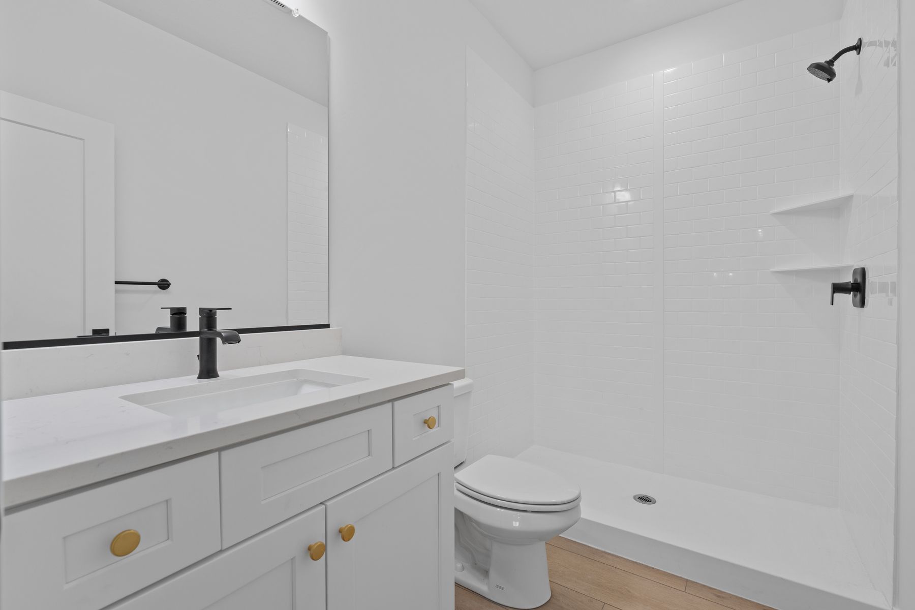 The secondary bathroom has a sprawling quartz vanity and large shower.