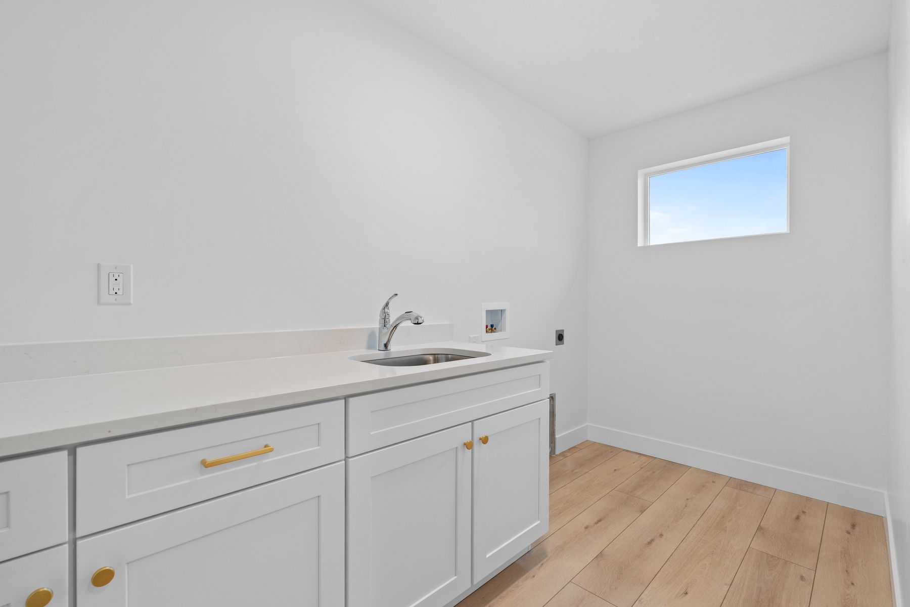 The laundry room has an extended counterspace with a sink for convenience.