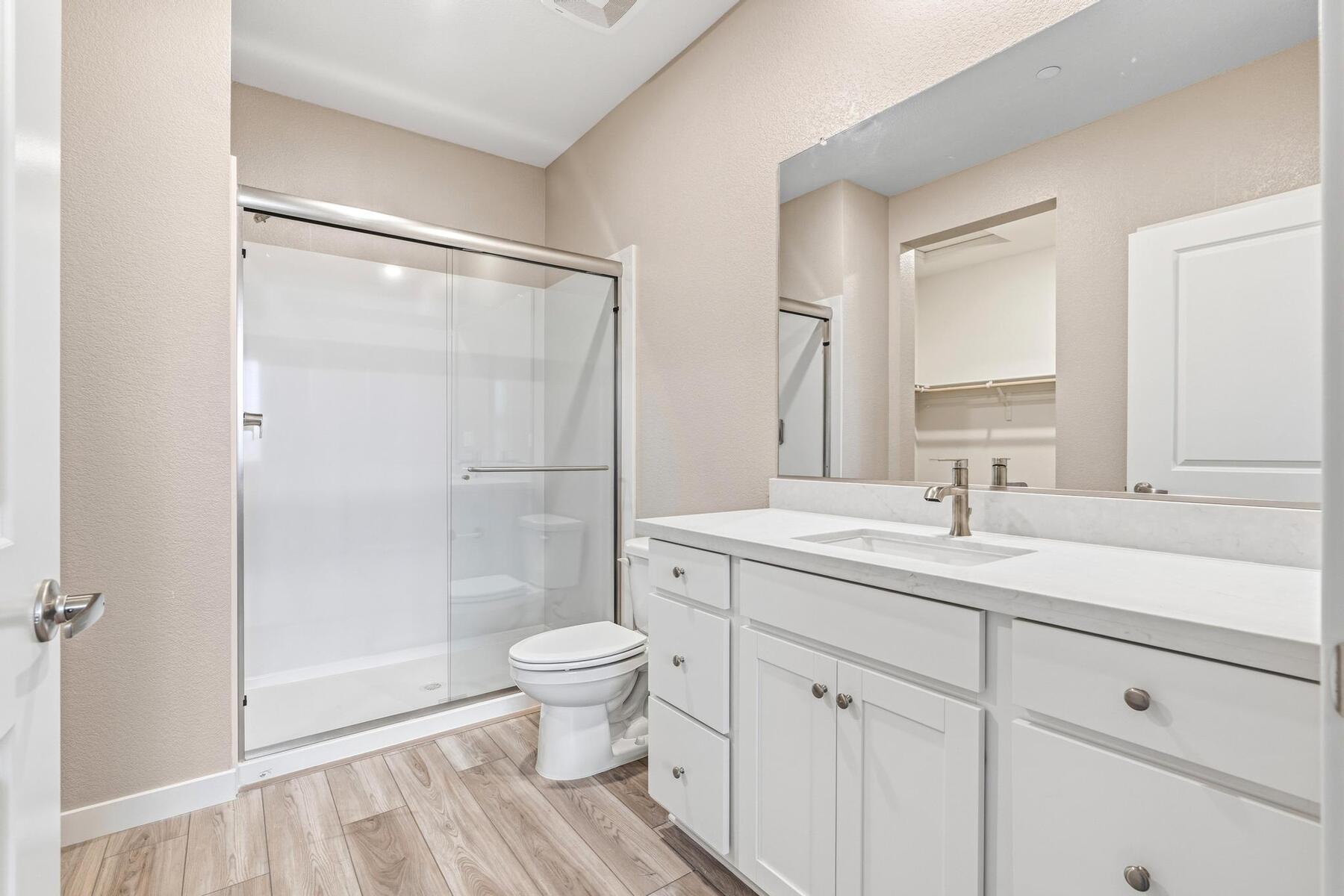 The master bathroom has a step in shower and large vanity
