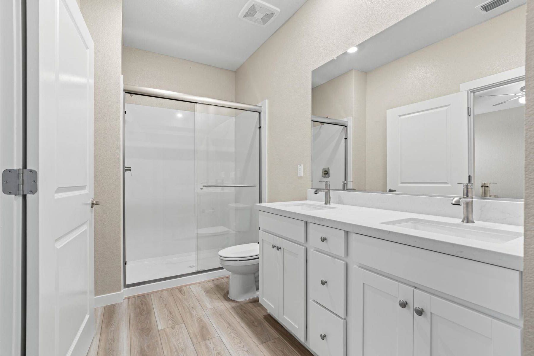 The master bathroom has a step in shower and large vanity.