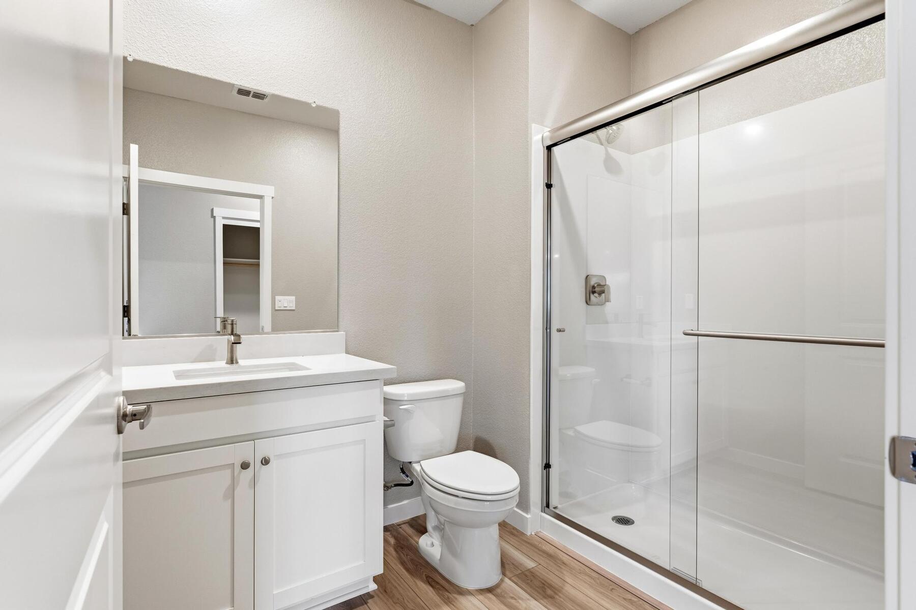The master bathroom has a large vanity with a step in shower.