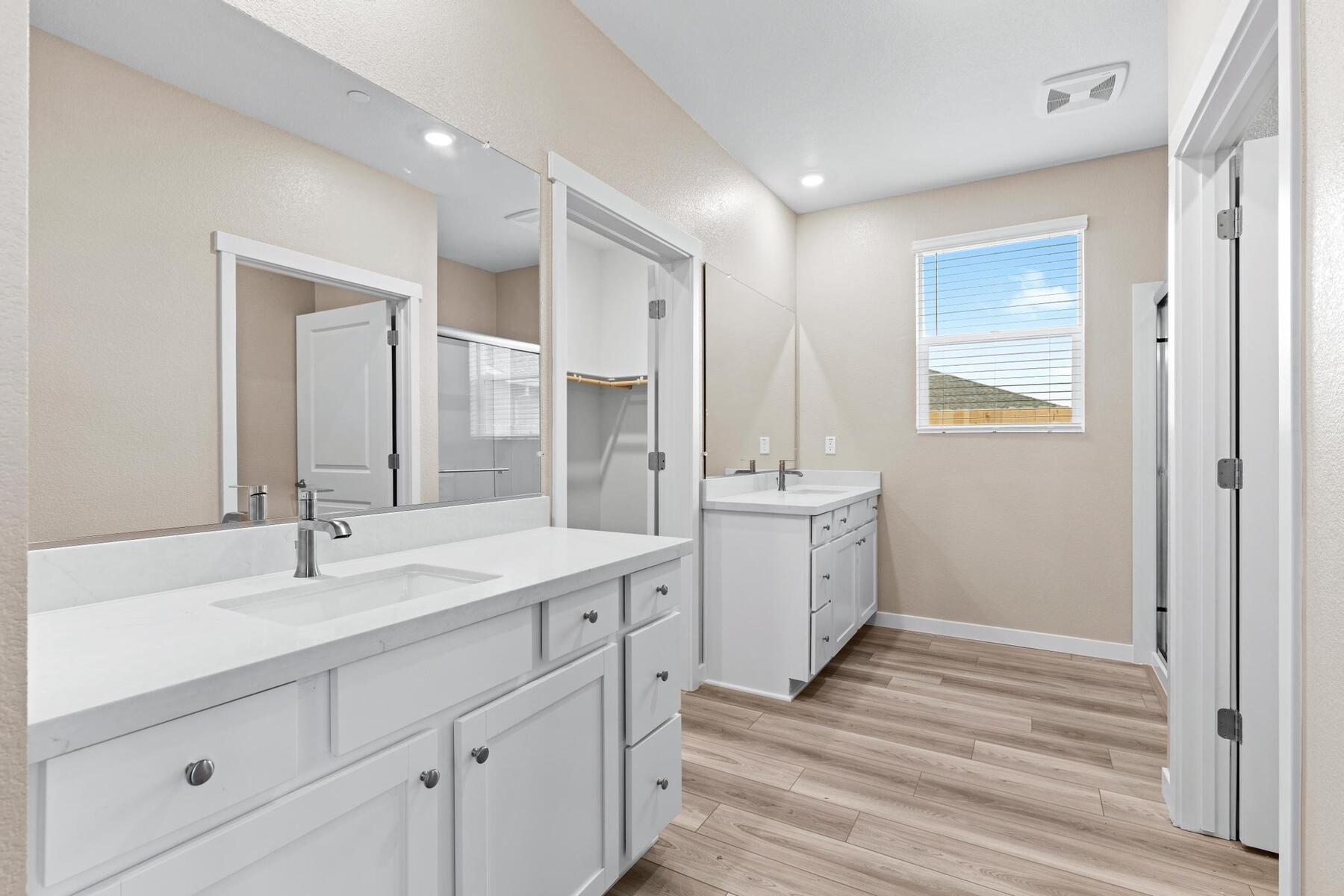 The master bathroom has a his and her sink and step in shower.