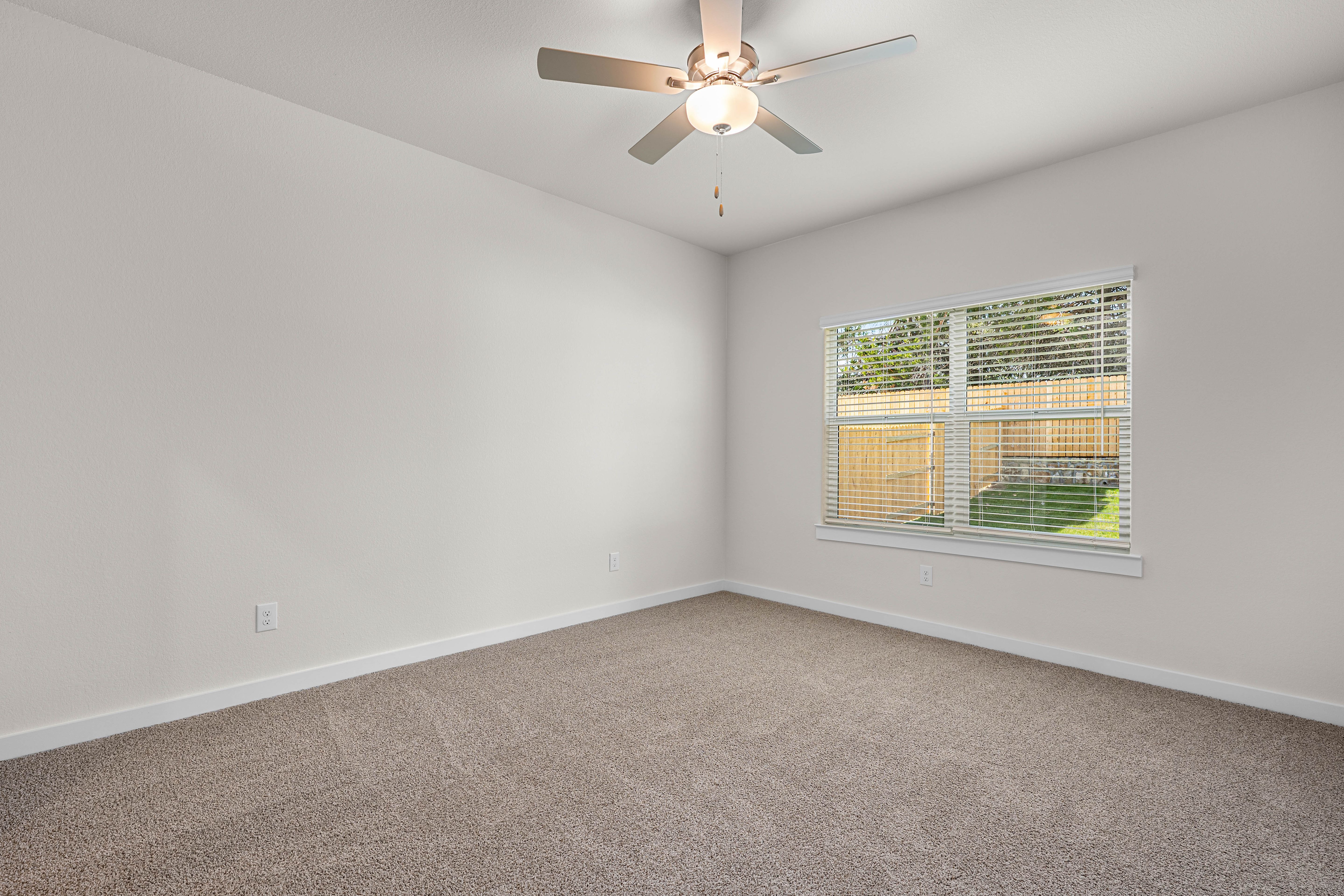 The spacious master bedroom has a window that lets in great, natural light and backyard views.