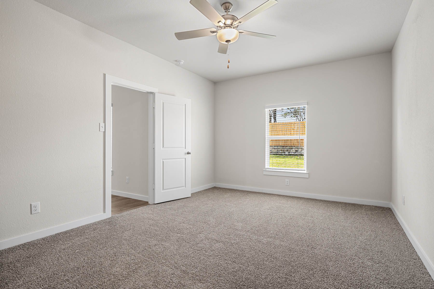 The spacious master bedroom has a window that lets in great, natural light and backyard views.