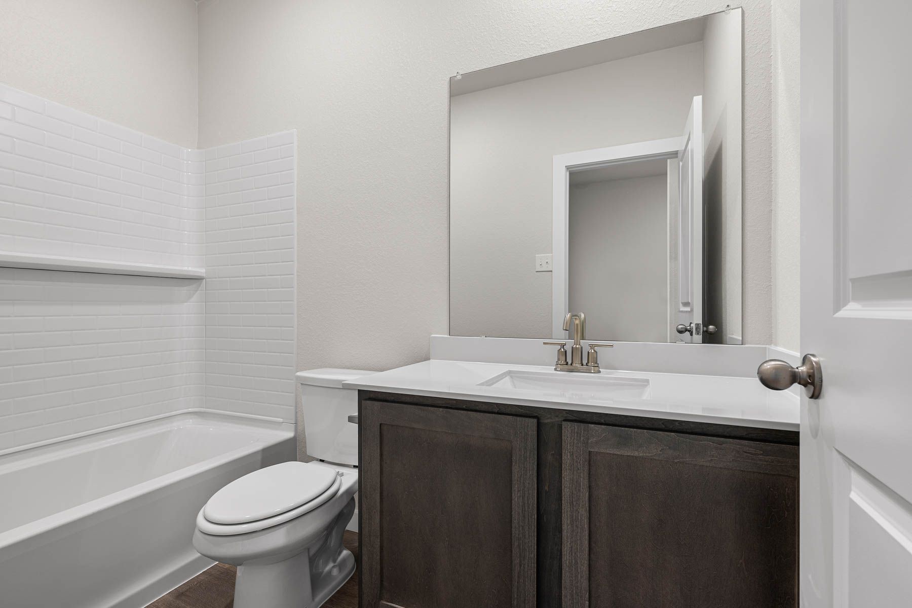 The secondary bathroom has a vanity space and a shower-tub combo.