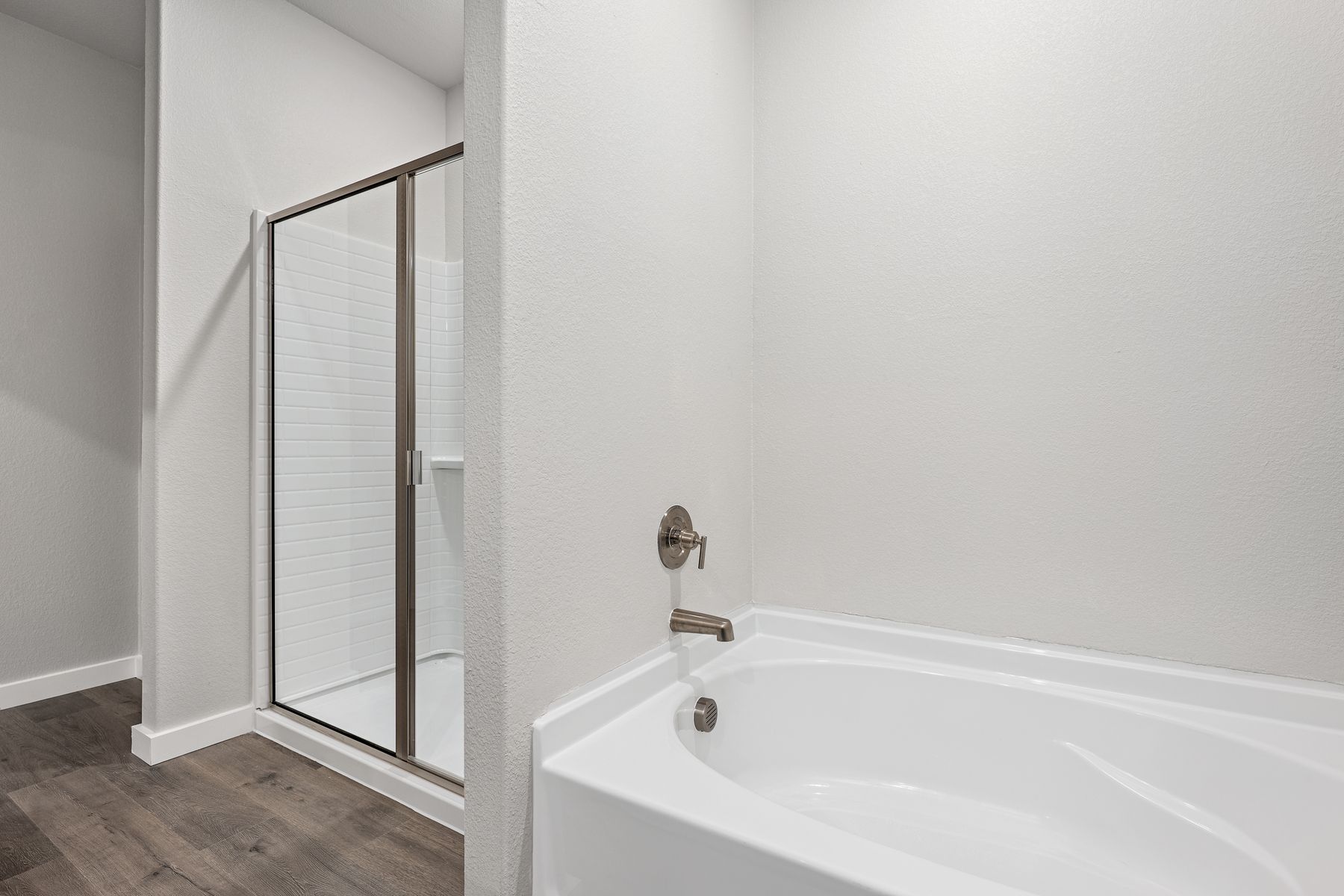 The master bathroom has a garden tub and glass, walk-in shower.