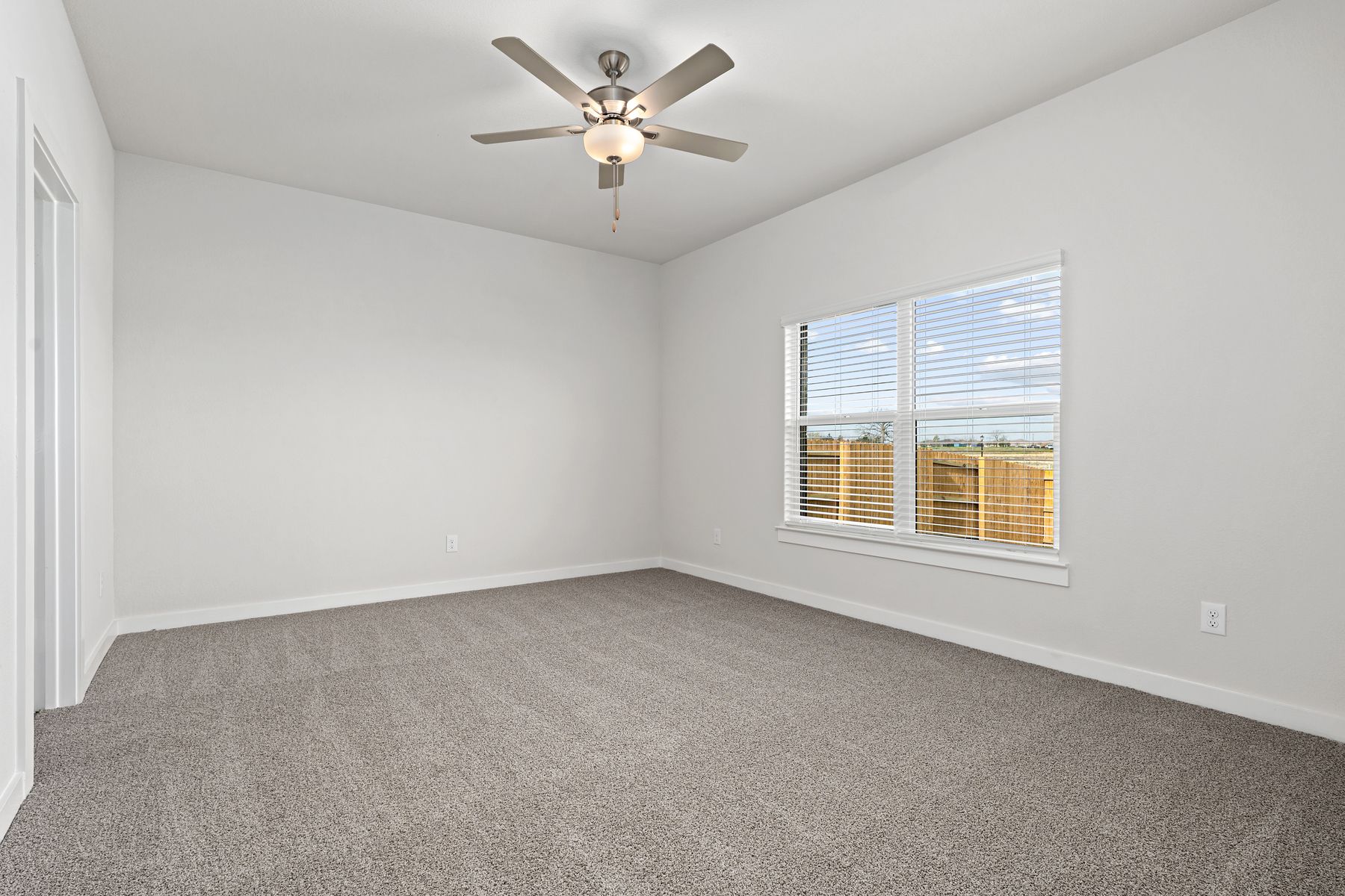 The spacious master bedroom has a window that lets in great, natural light and backyard views.