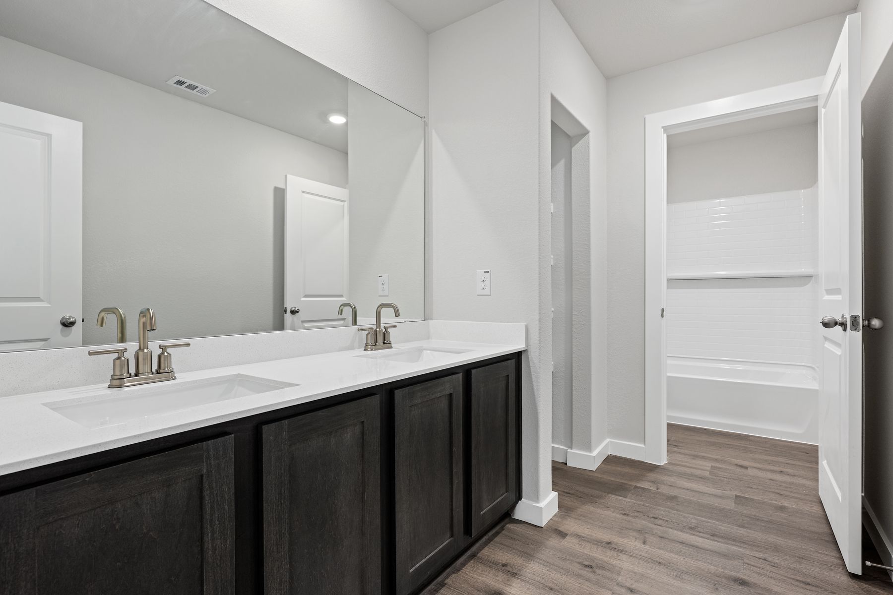 The secondary bathroom has a vanity space and a shower-tub combo.