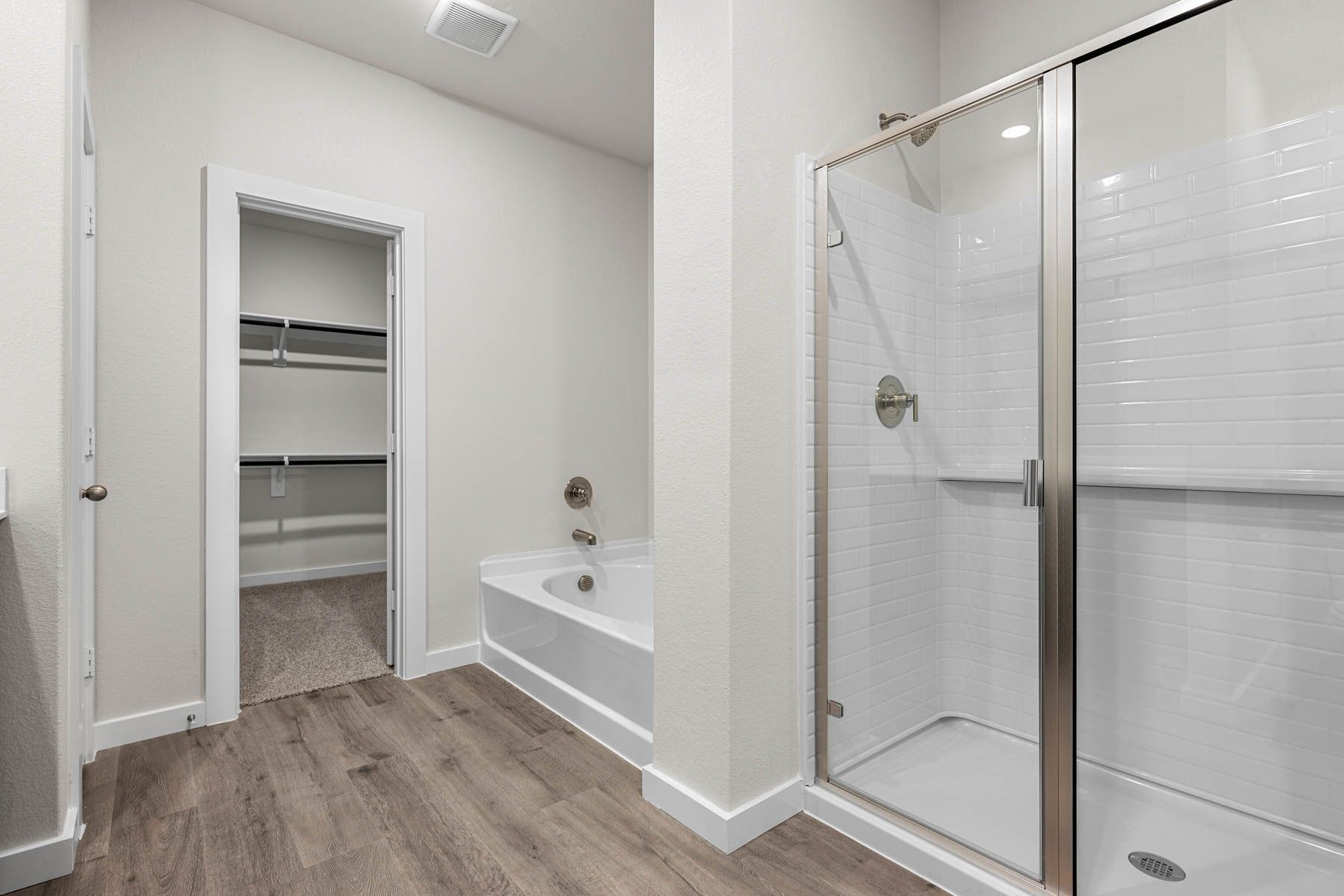 The master bathroom has a glass, walk-in shower and garden tub.