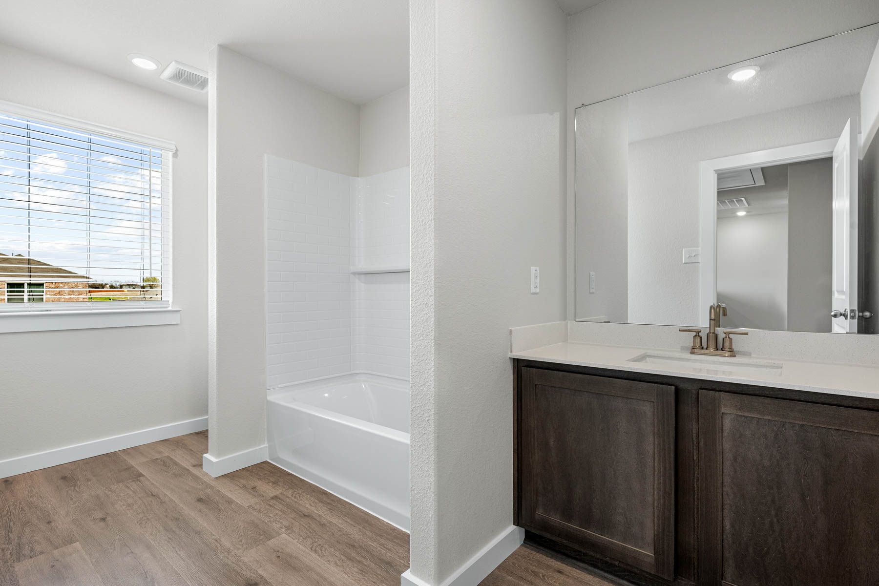 The secondary bathroom has a vanity space and a shower-tub combo.