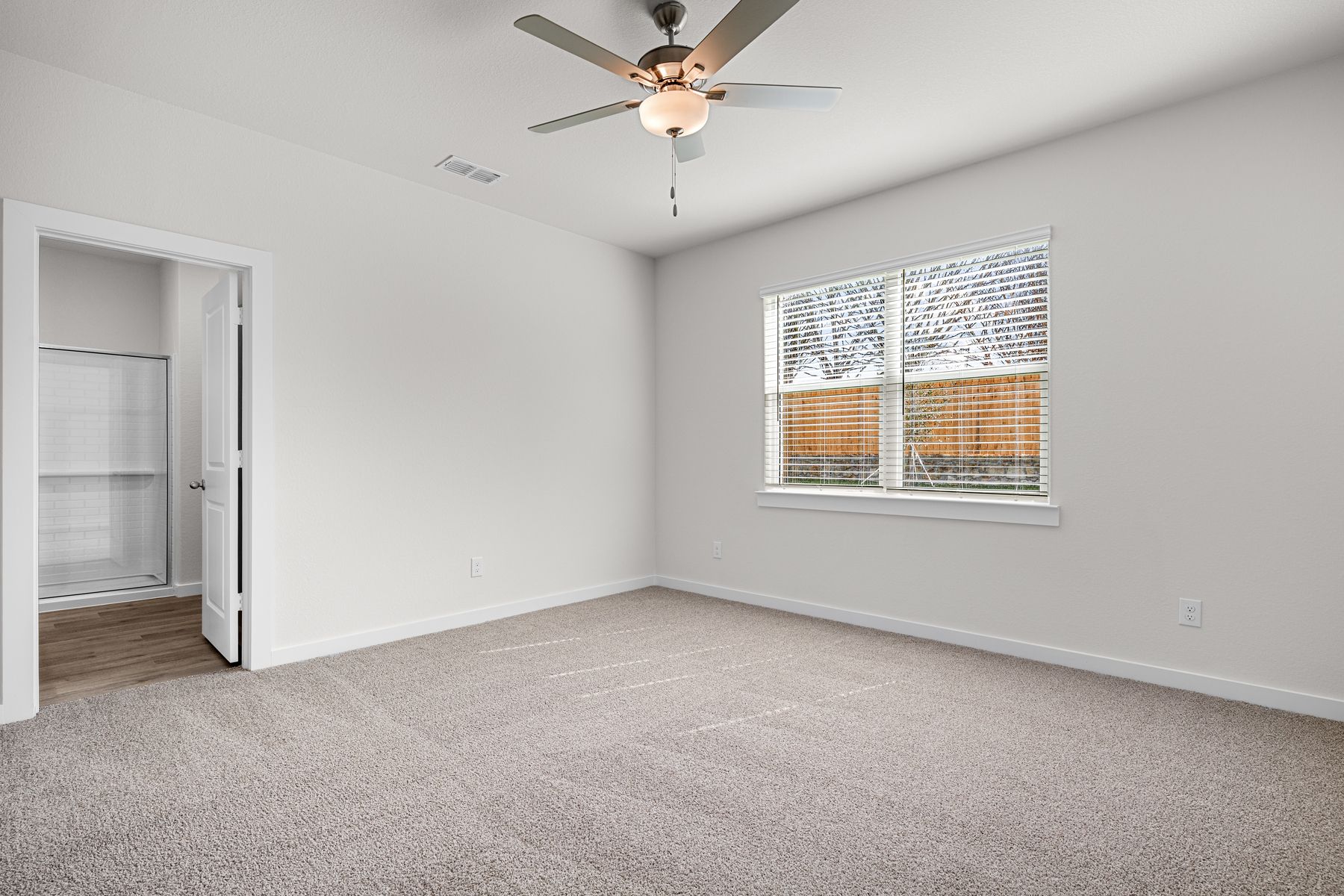 The spacious master bedroom has a window that lets in great, natural light and backyard views.