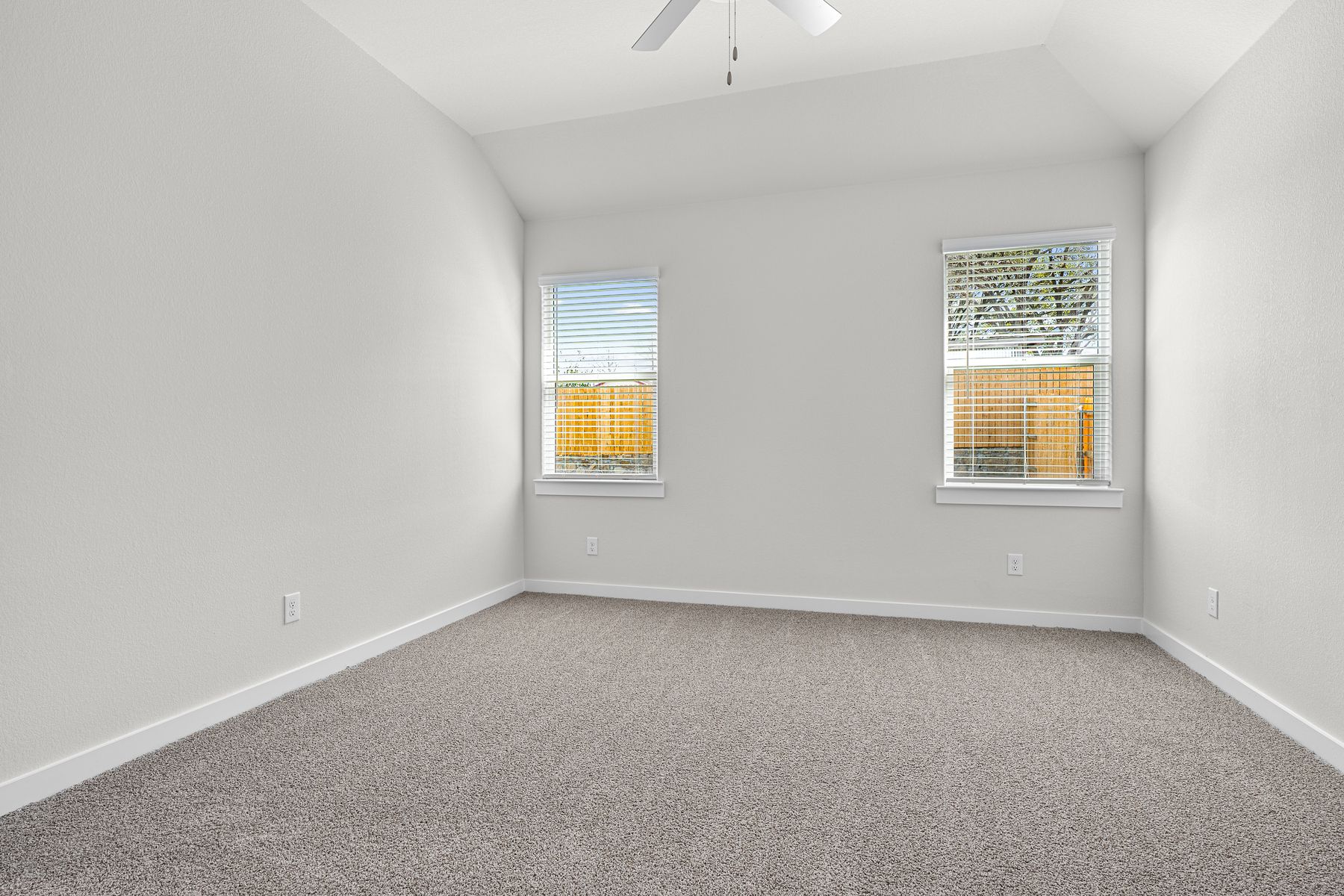 The spacious master bedroom has two windows that lets in great, natural light and backyard views.