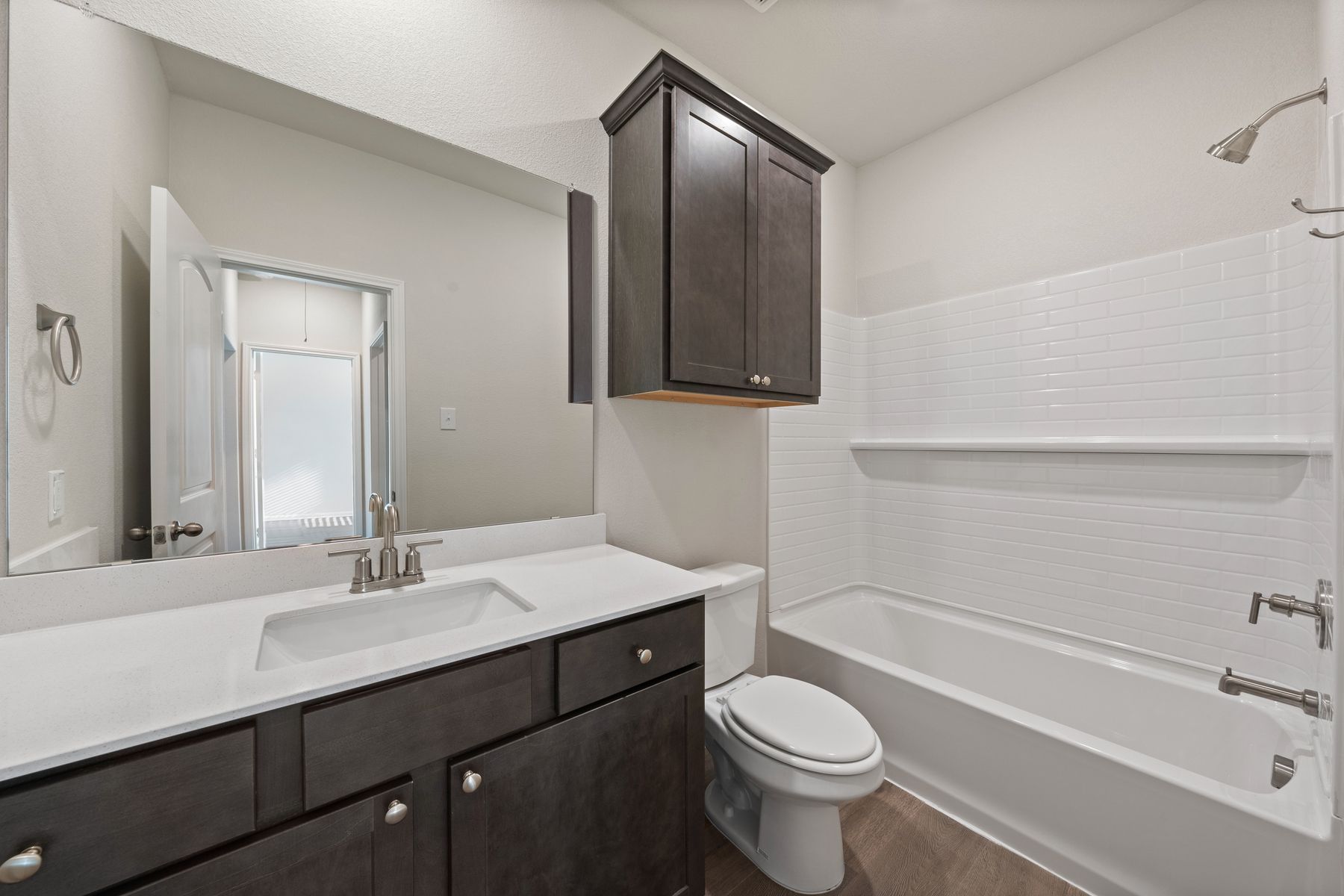 The secondary bathroom has a sprawling vanity and shower-tub combo.