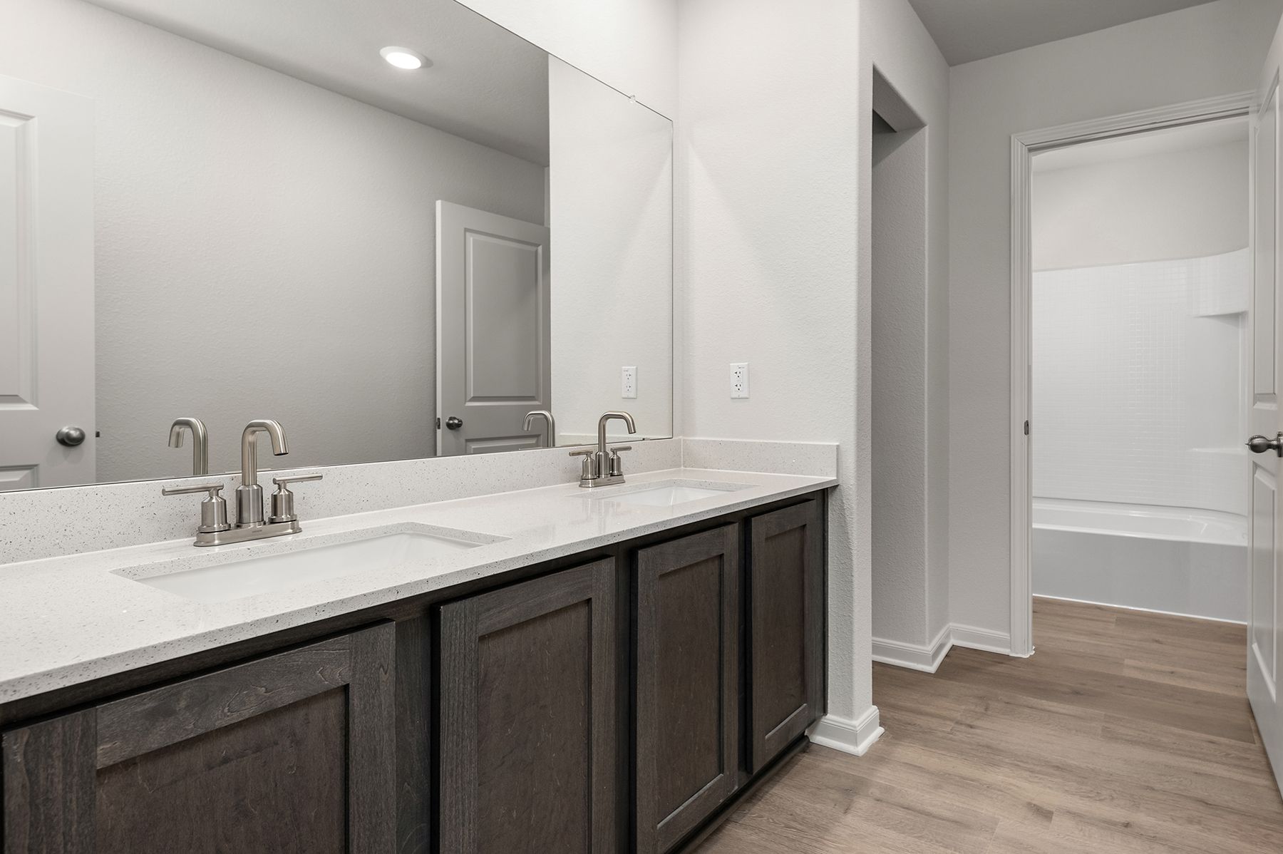 The secondary bathroom has a sprawling dual-sink vanity and shower-tub combo. 