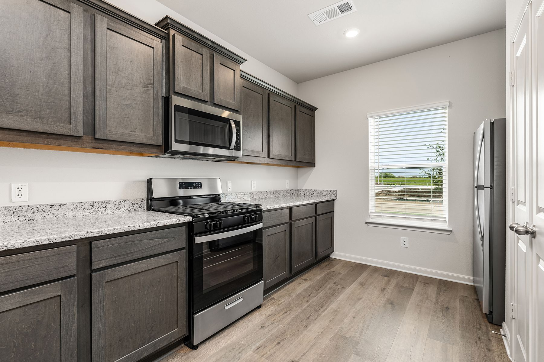 The kitchen has beautiful wood cabinetry and sprawling granite countertops.