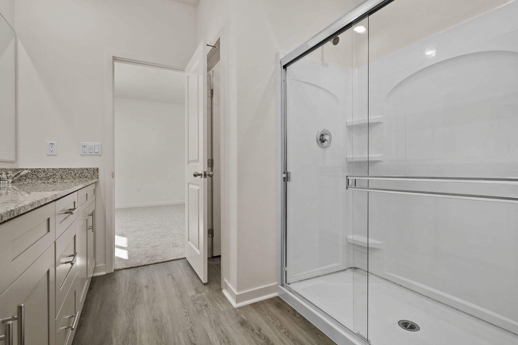 The master bathroom has a large vanity with a step in shower.