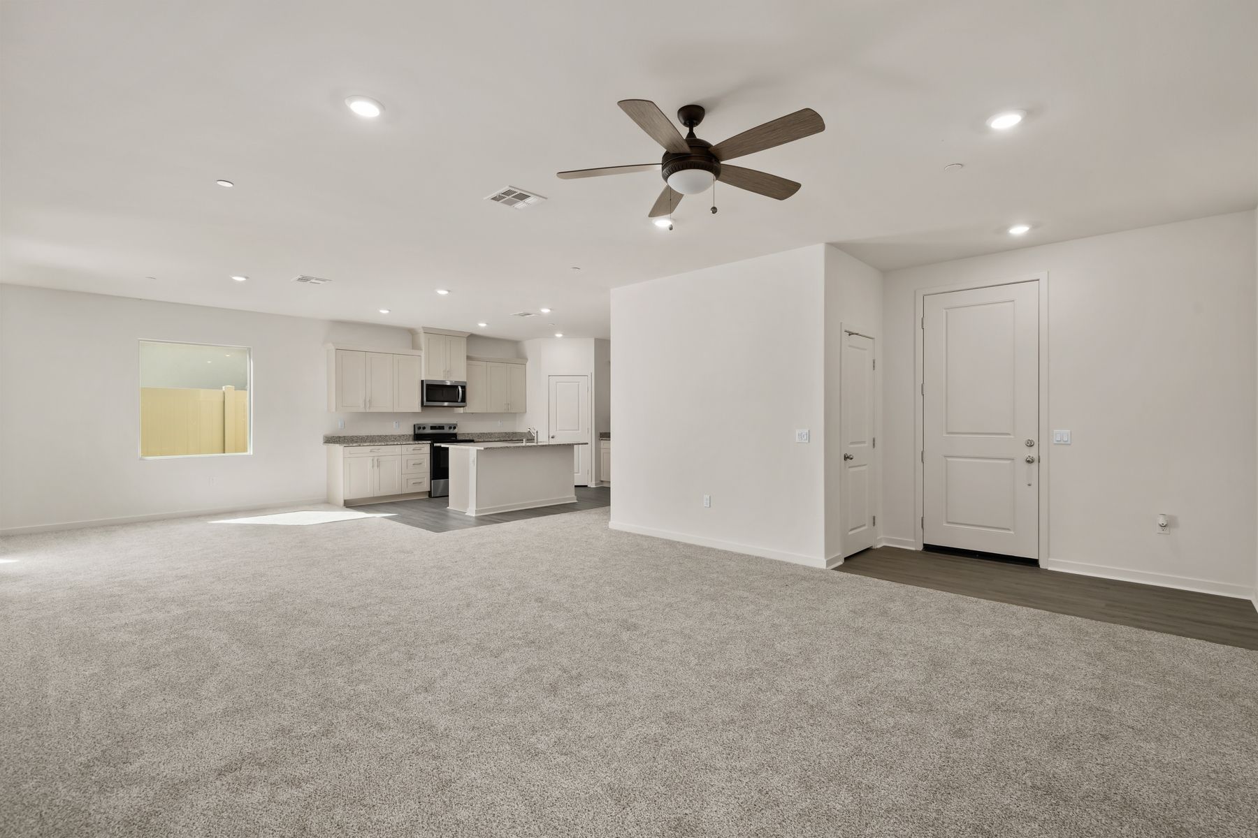 The family room is spacious with a ceiling fan.