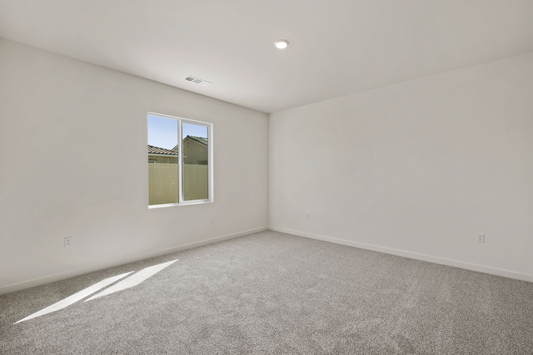The master bedroom is spacious with a large window.