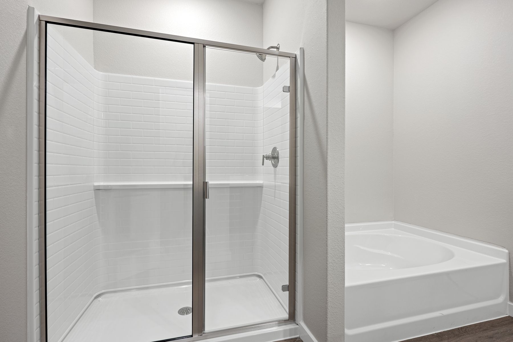 The master bathroom has a garden tub and glass, walk-in shower.