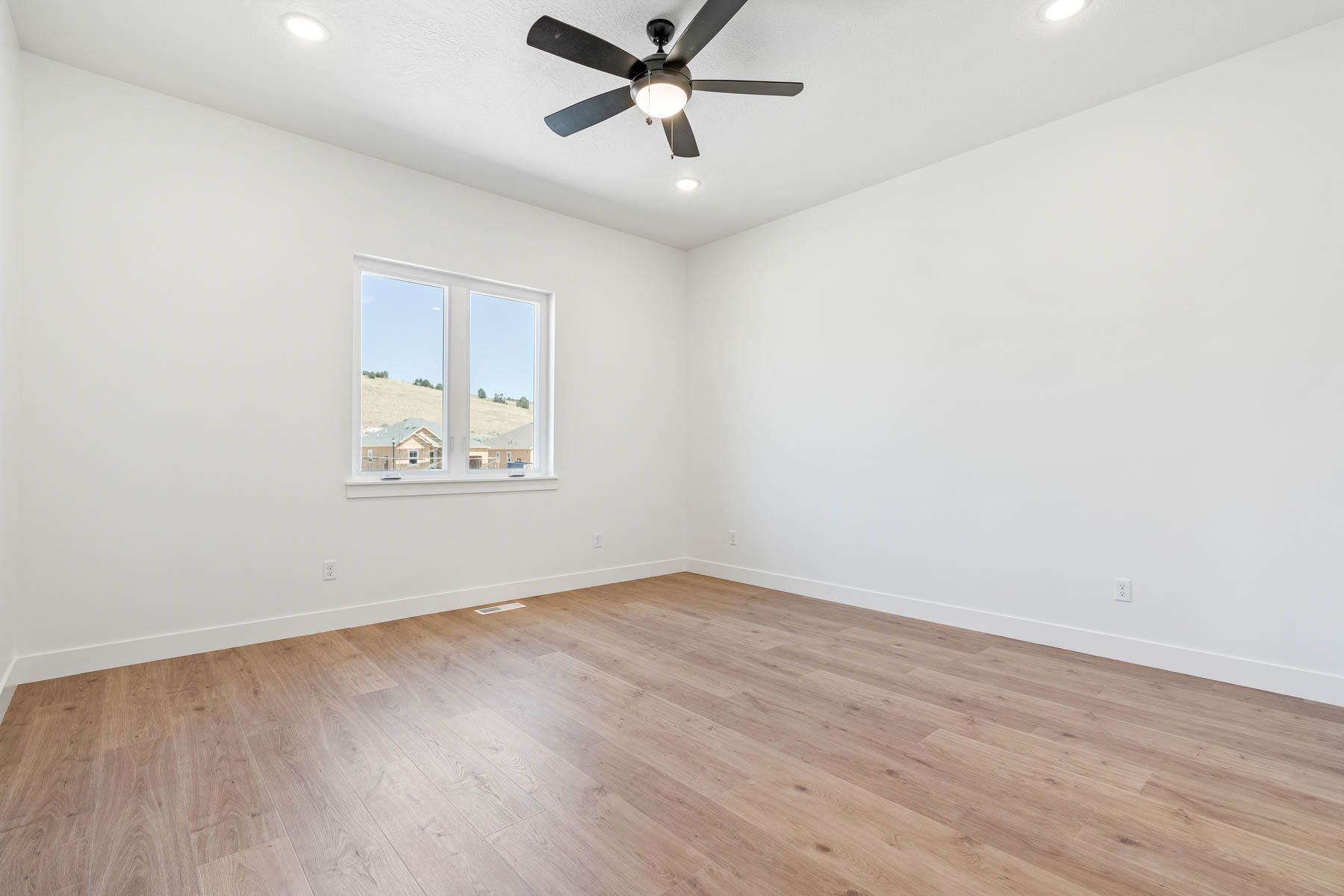The master bedroom is spacious and has a large window.