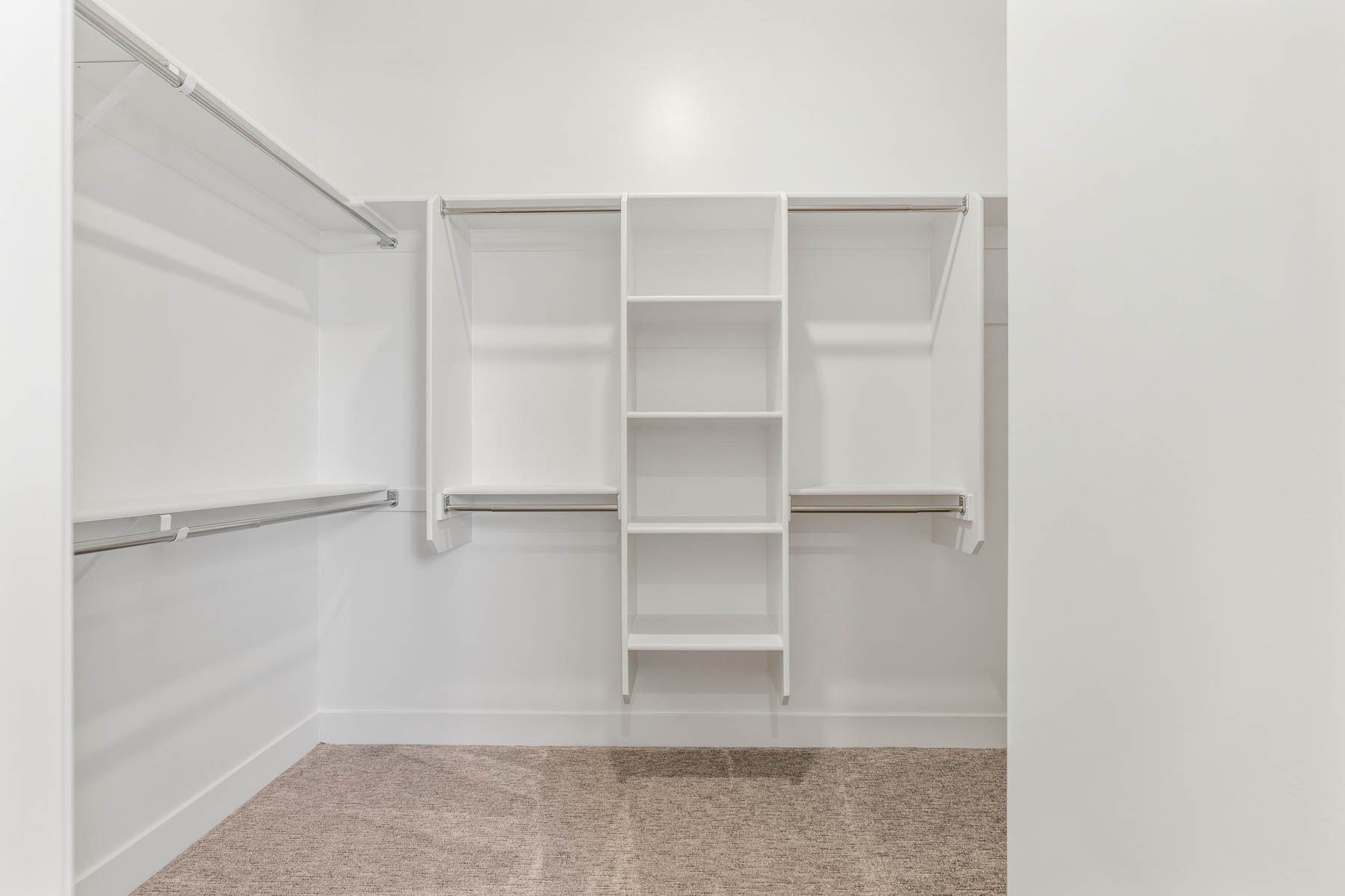 The master closet is spacious and has hanging space and shelves.