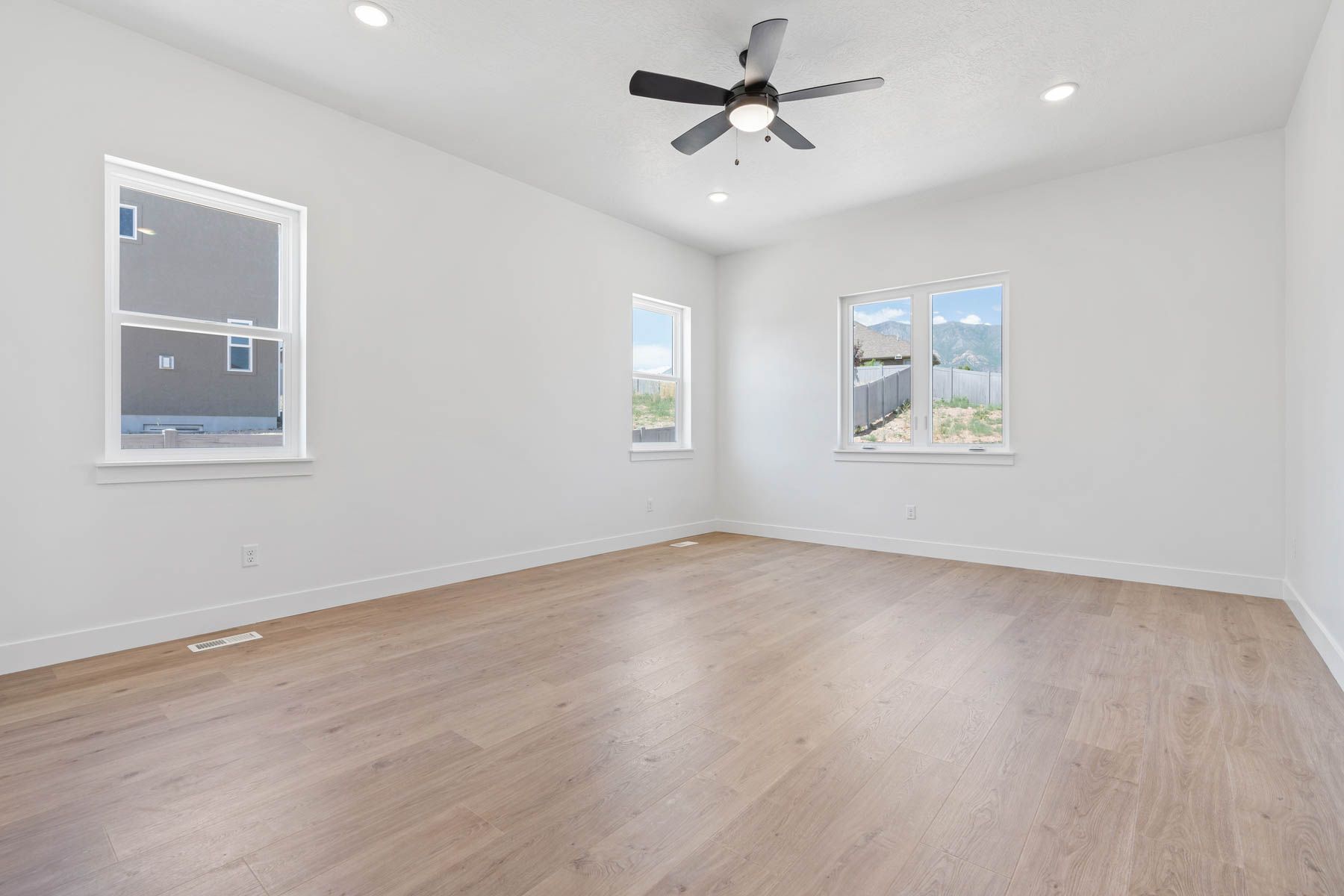 The master bedroom is spacious and has lots of large windows.