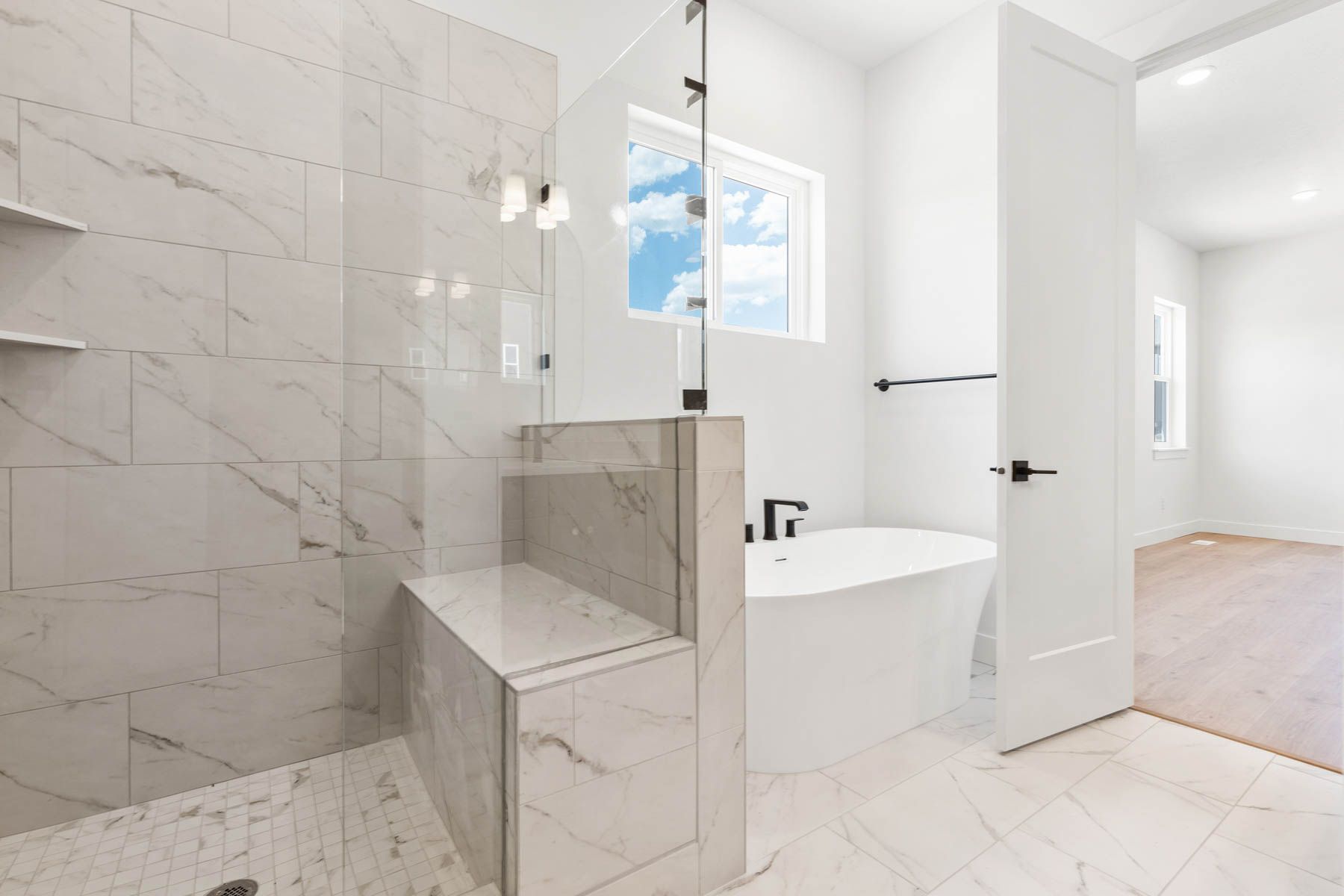 The master bathroom has a glass, walk-in shower and a soaker tub. 