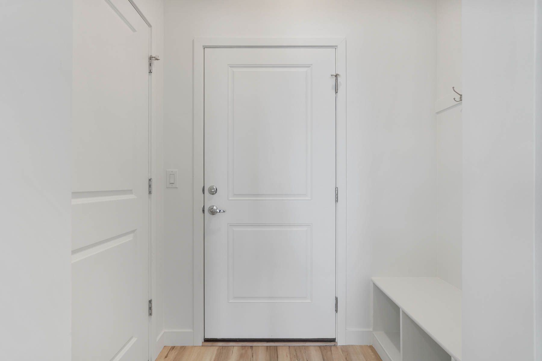 The mudroom has a storage bench and hooks.
