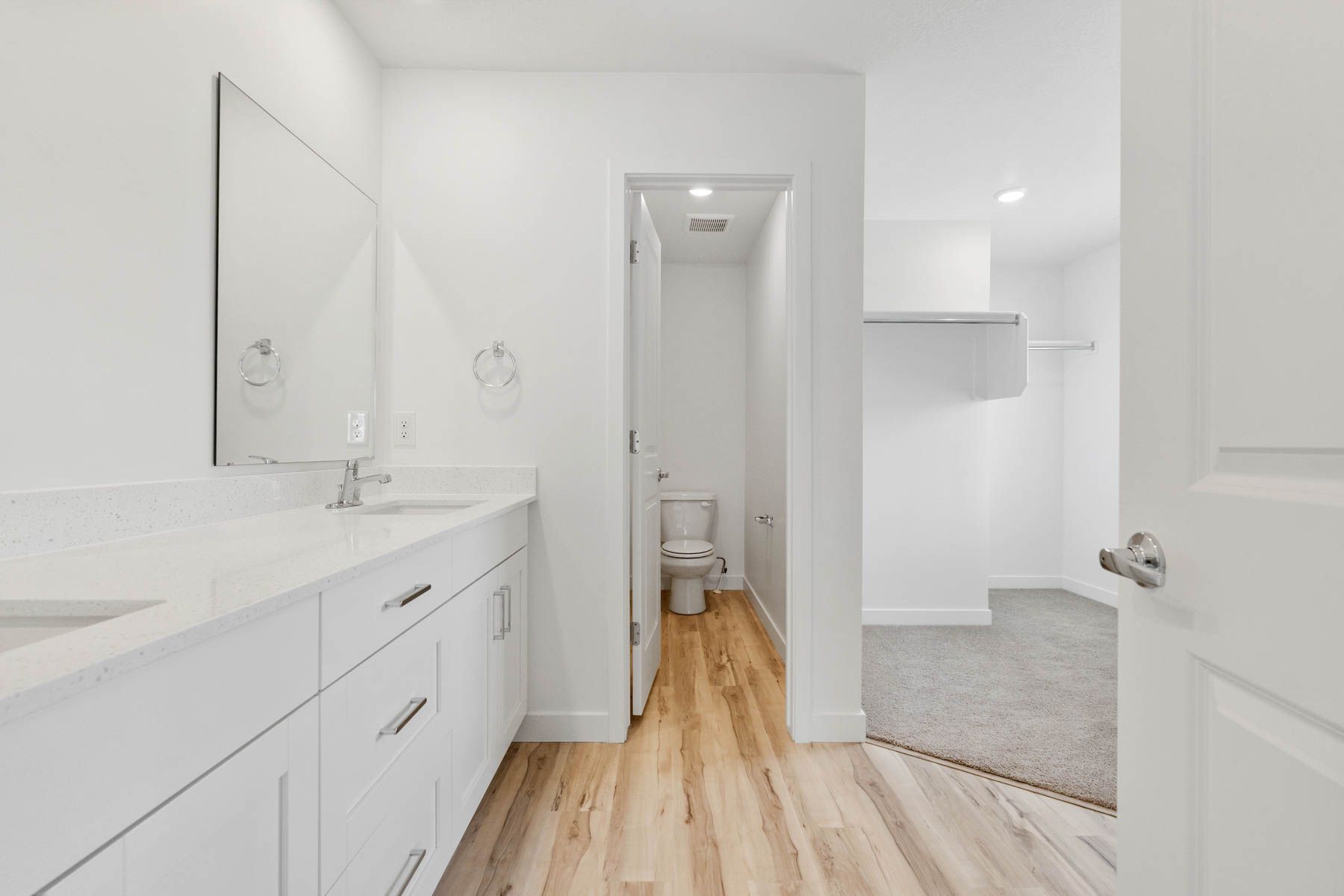 The master bathroom has a sprawling dual-sink vanity and private toilet room.