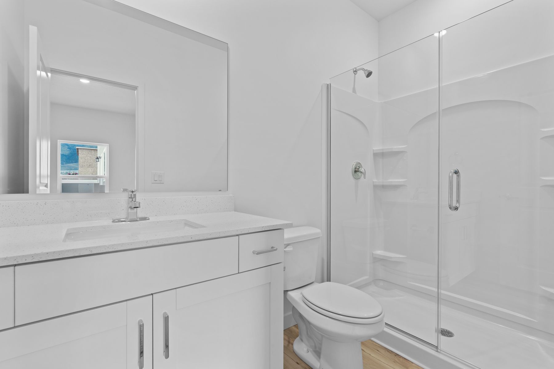 The master bathroom has a sprawling vanity and glass, walk-in shower.