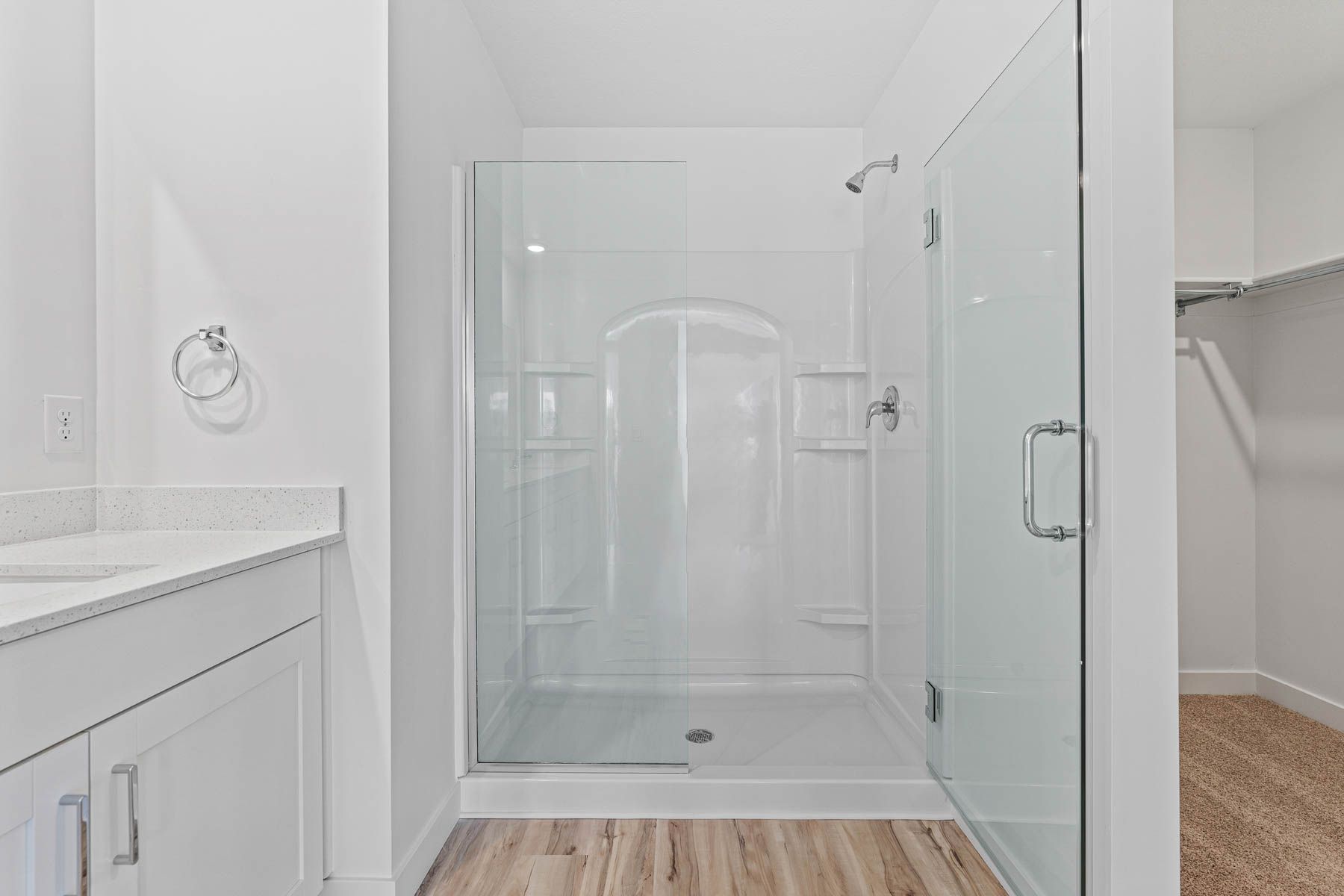 The glass walk-in shower has convenient shelving. 