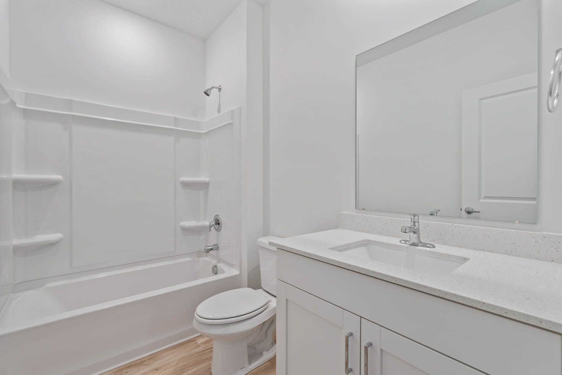 The secondary bathroom has a sprawling vanity and shower-tub combo.