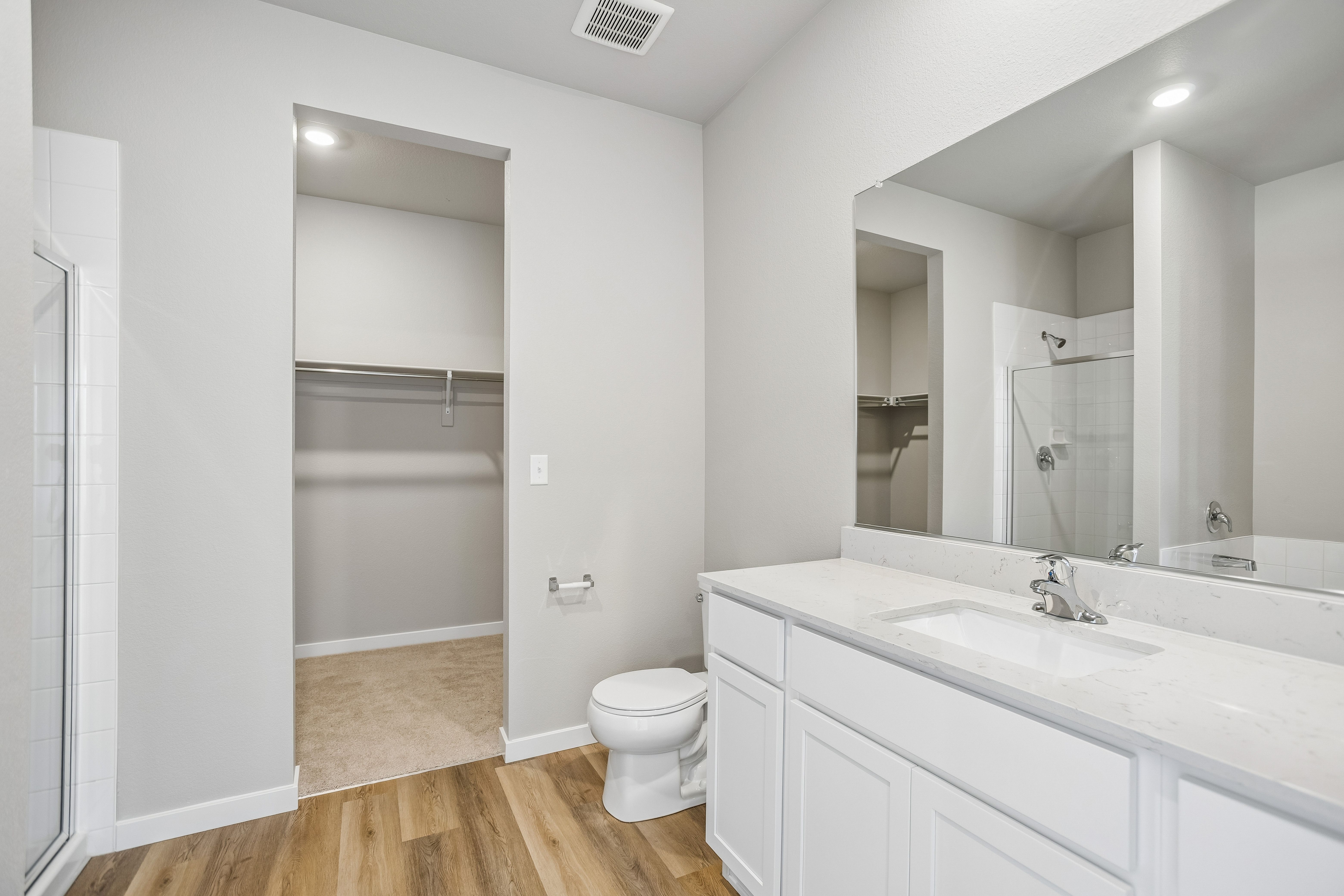 The master bathroom has a large vanity with a step in shower and soaking tub.