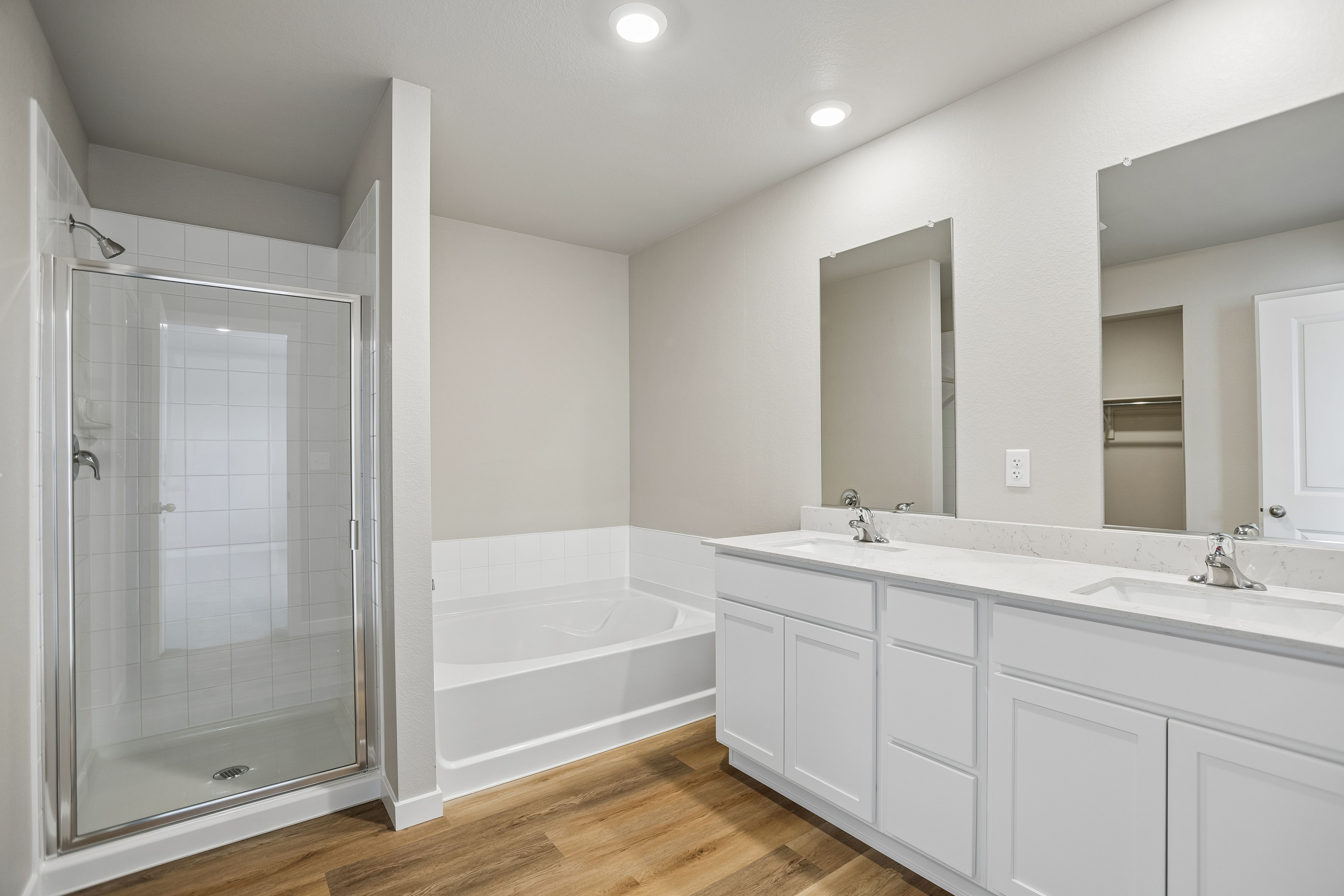 The master bathroom has a large vanity with a step in shower and soaking tub